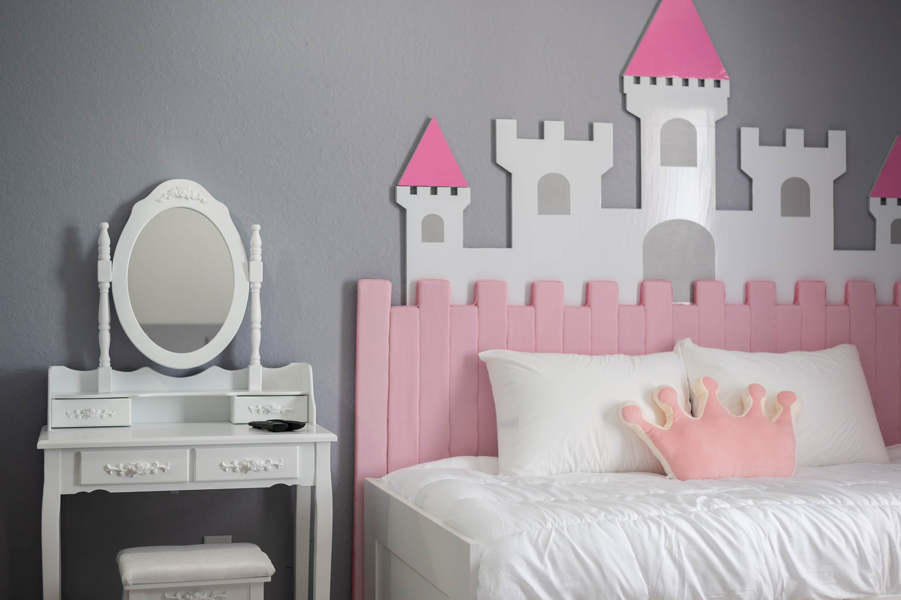 Charming bed setup w/ castle headboard & playful pink accents