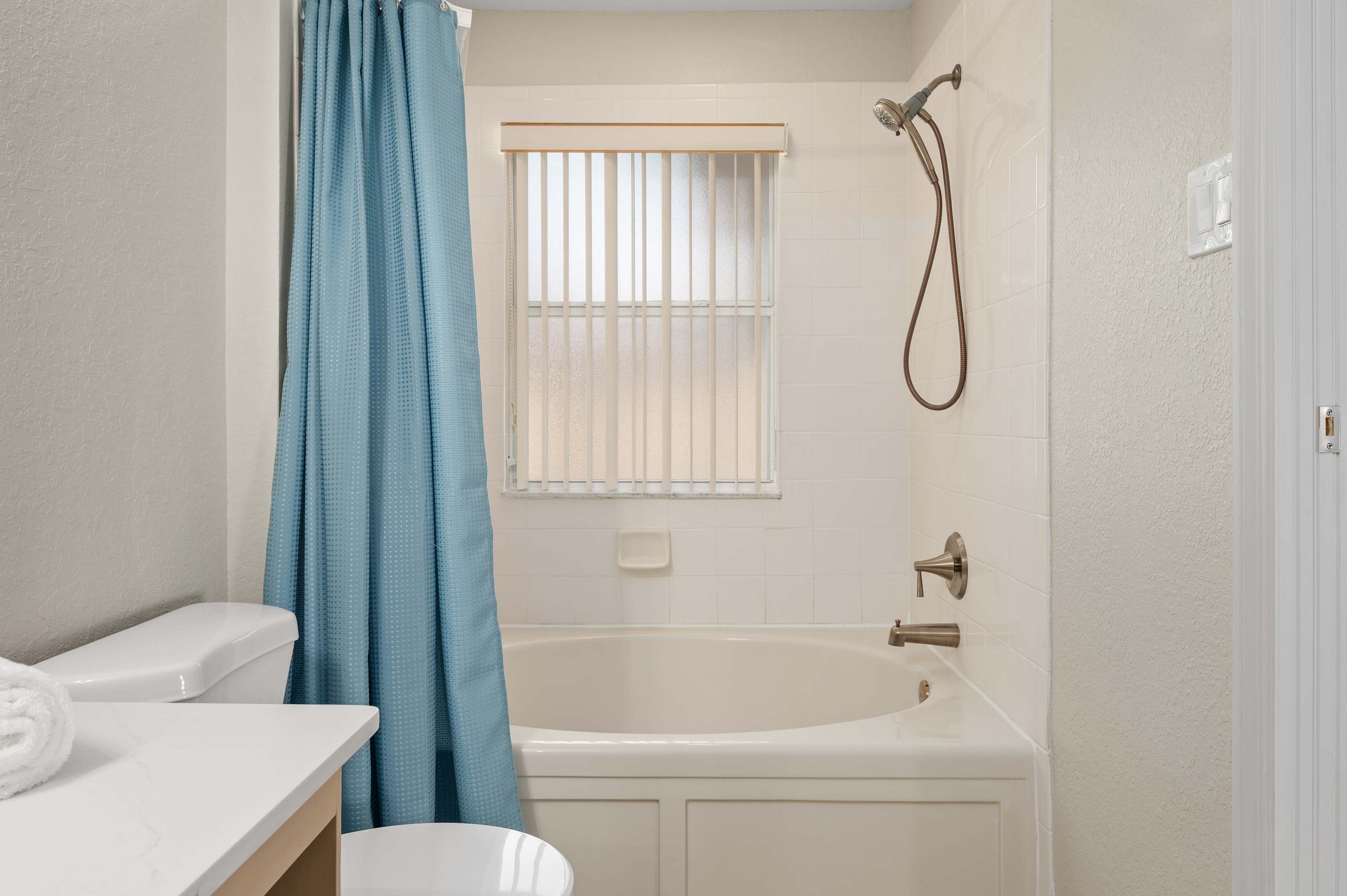 Full bathroom w/ shower & tub combo, bright curtain & clean finishes