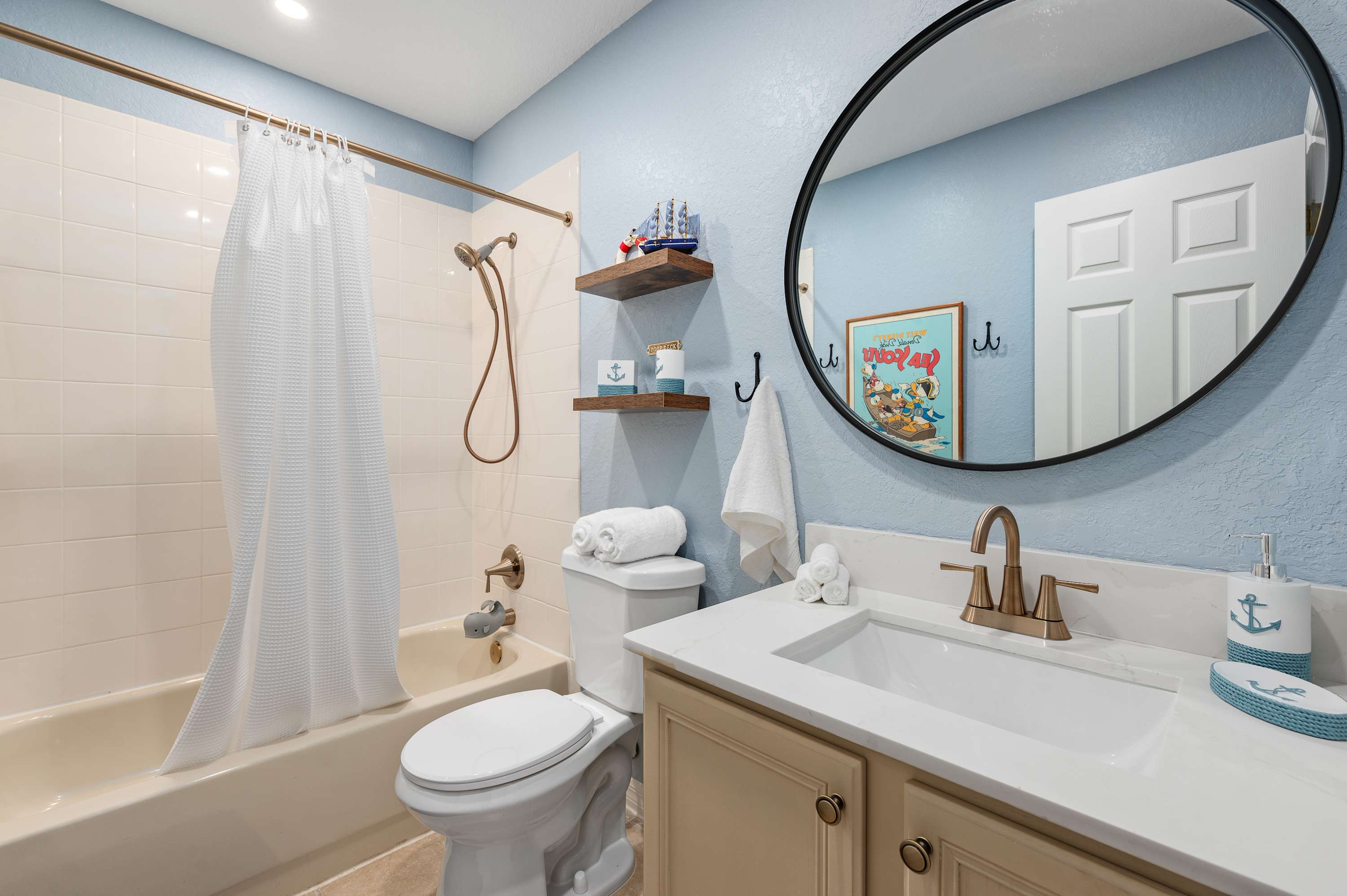 Clean bathroom w/ shower & tub combo, soft tones & simple design