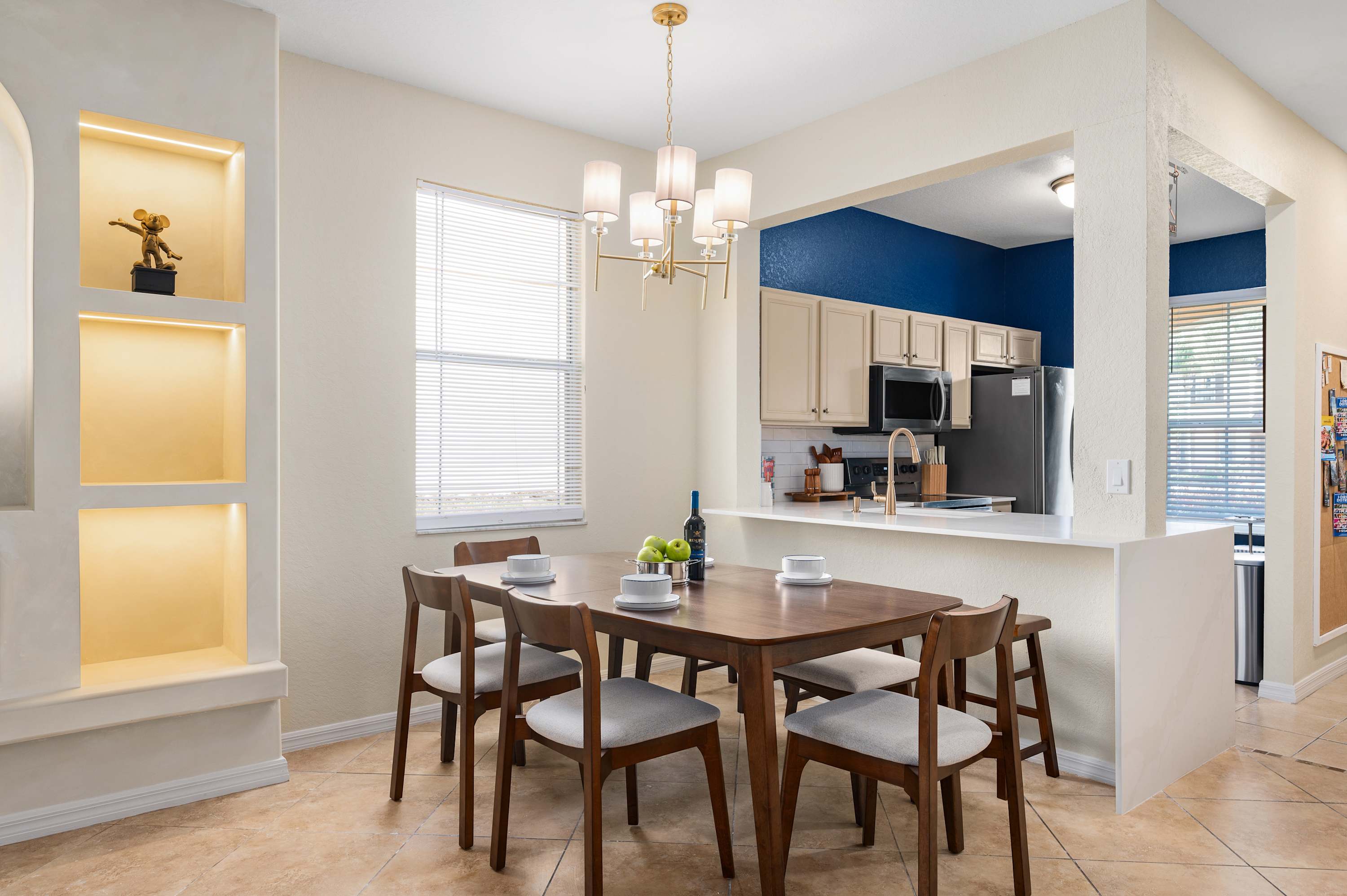 Dining space w/ statement lighting, flowing into a stylish kitchen for easy meals