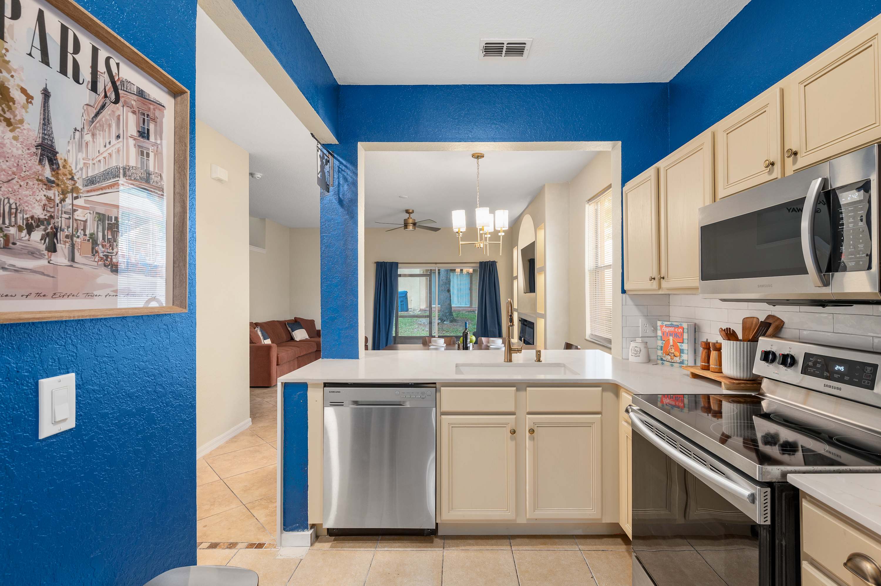 Long galley kitchen w/ blue walls & plenty of storage throughout