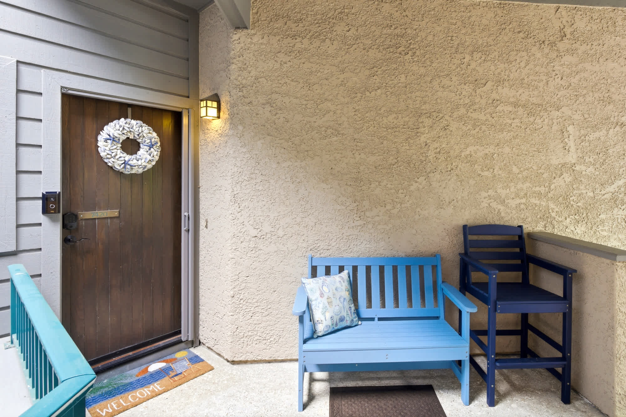 Shell-wreath welcome and an Adirondack-style bench for that 'we're really on vacation' moment before you even step inside.