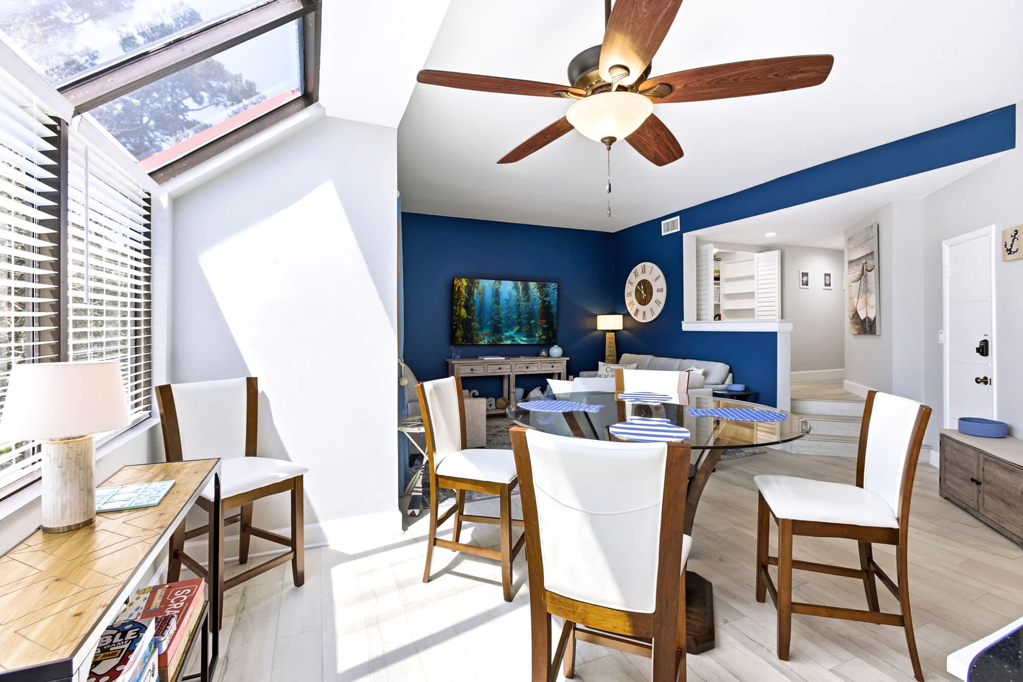 Open-concept dining and lounging - bold blue accent wall and high ceilings create a room that feels both cozy and airy.