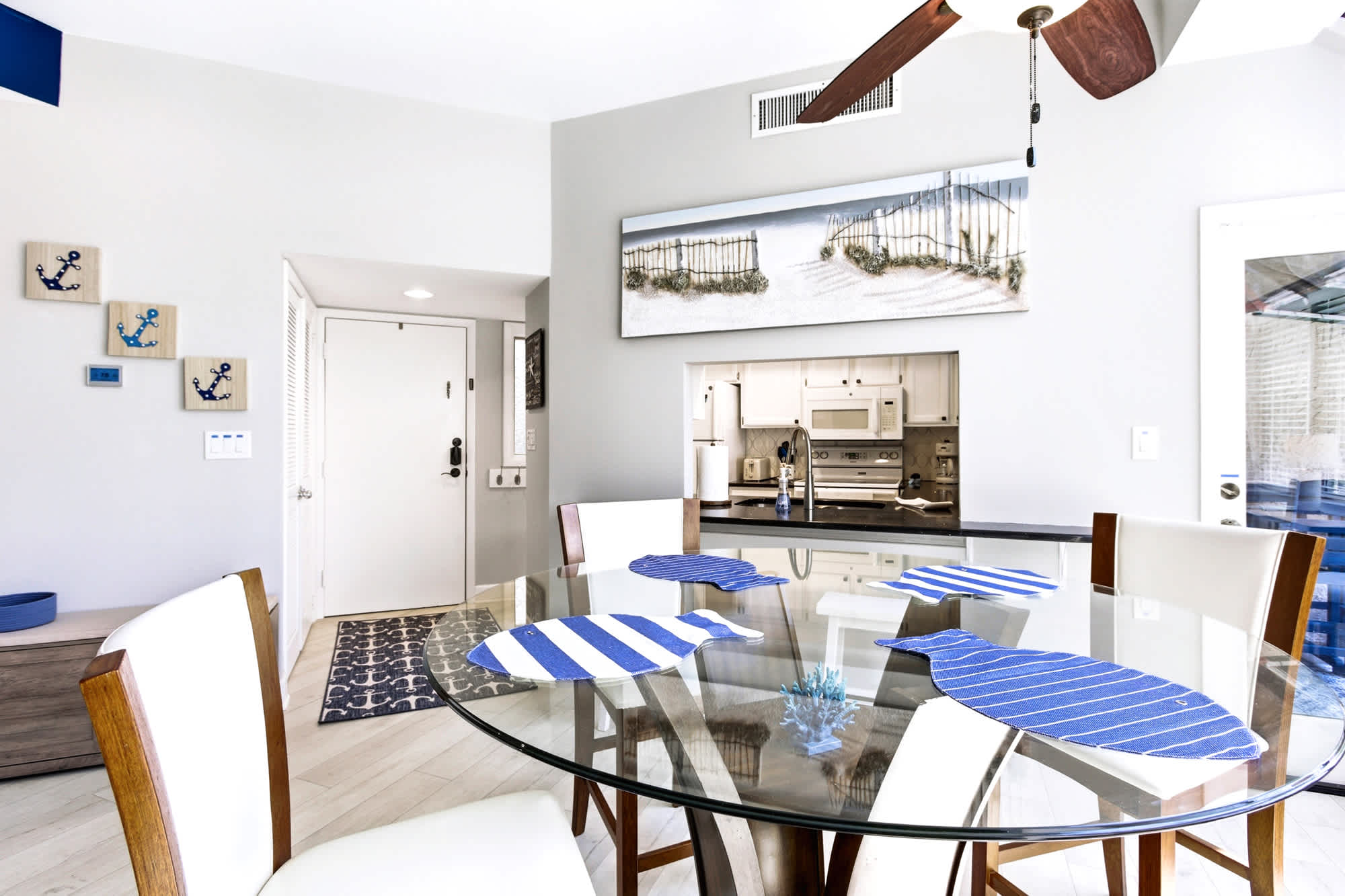 Glass table for four, nautical accents, and that easy beach-house feel throughout.