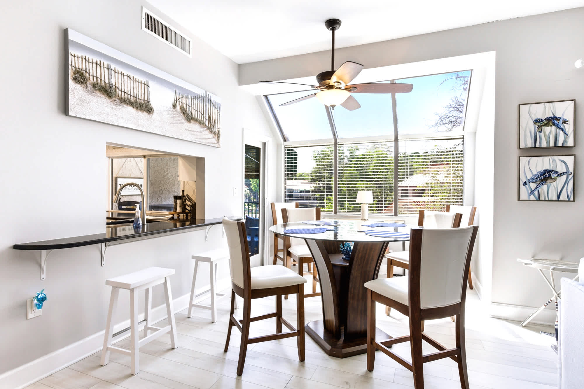 Counter-height dining table for four with a built-in pass-through to the kitchen - easy family meals with big windows letting the light pour in.