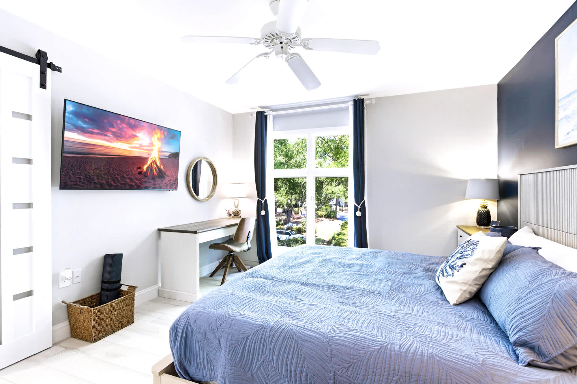 Comfortable king bed with a wall-mounted TV and a small writing desk by the window - perfect for guests or a few catch-up emails.
