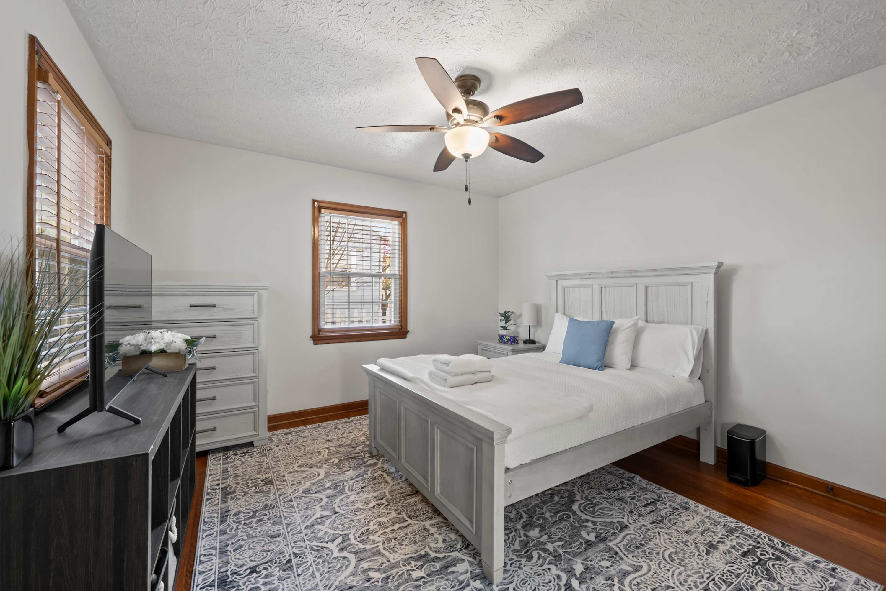 This main-floor bedroom offers a plush full-sized bed & smart TV​