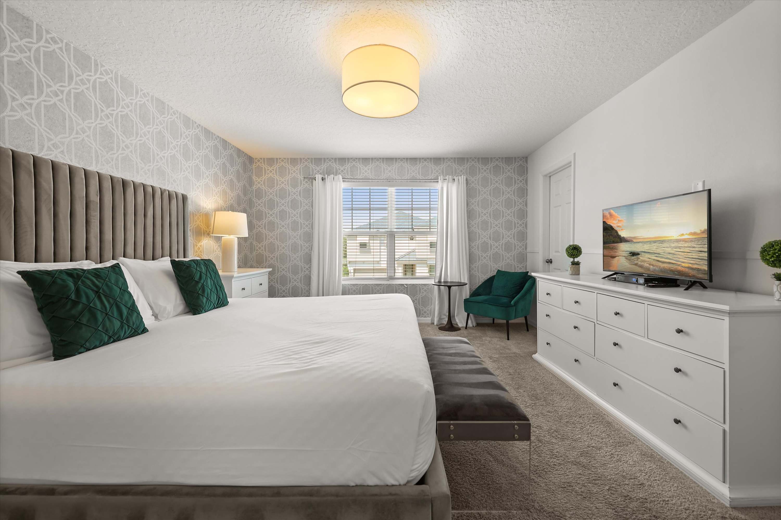 Bedroom with king bed, ceiling fan, Smart TV, and a dedicated workspace, designed for both relaxation and productivity.