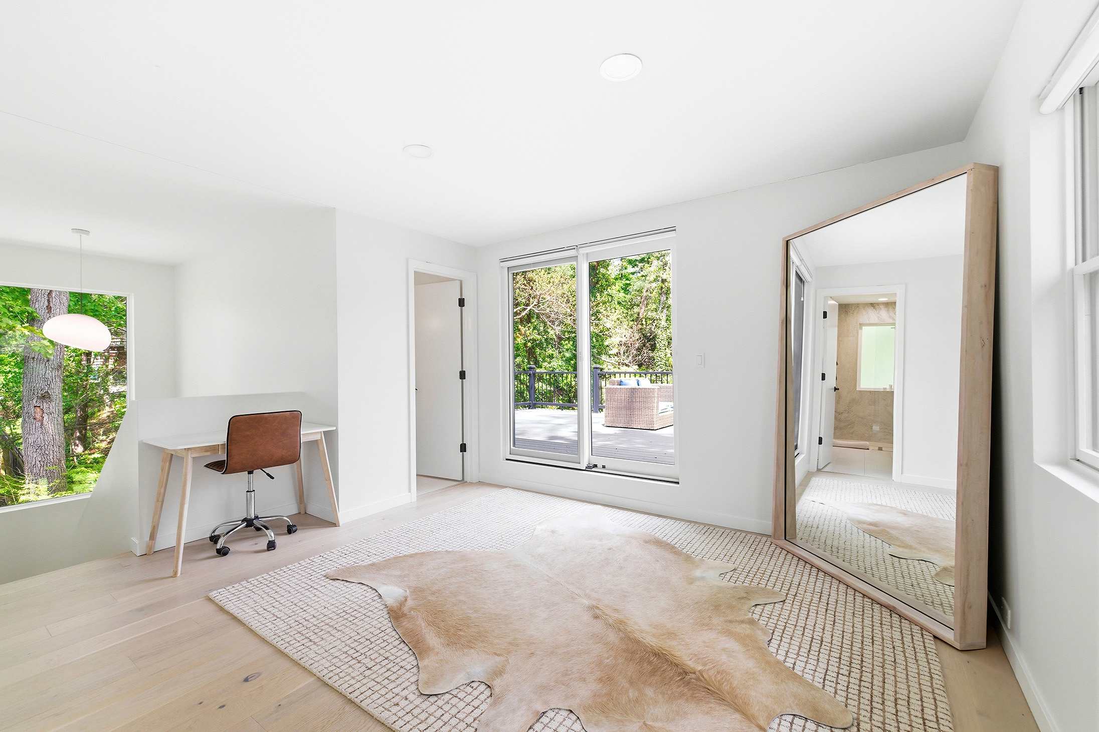 This room’s got main character energy: natural light, a statement mirror, and a balcony to top it off.
