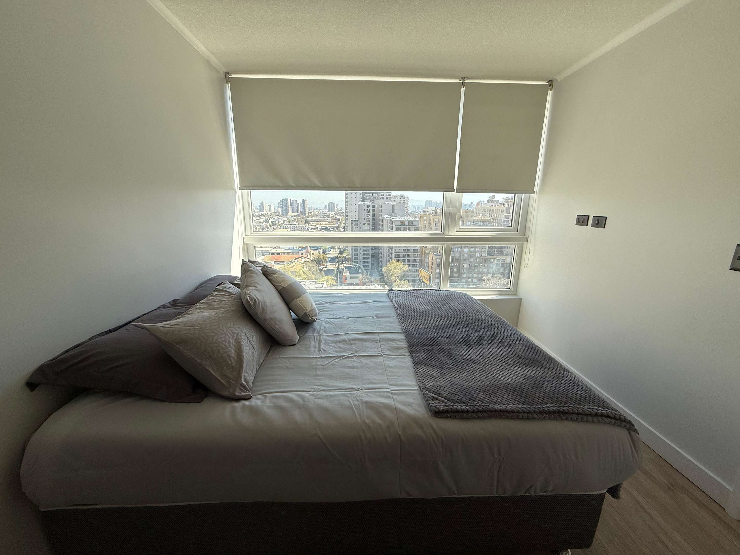 Relax in this cozy bedroom with stunning city views, perfect for unwinding after a day of exploring.