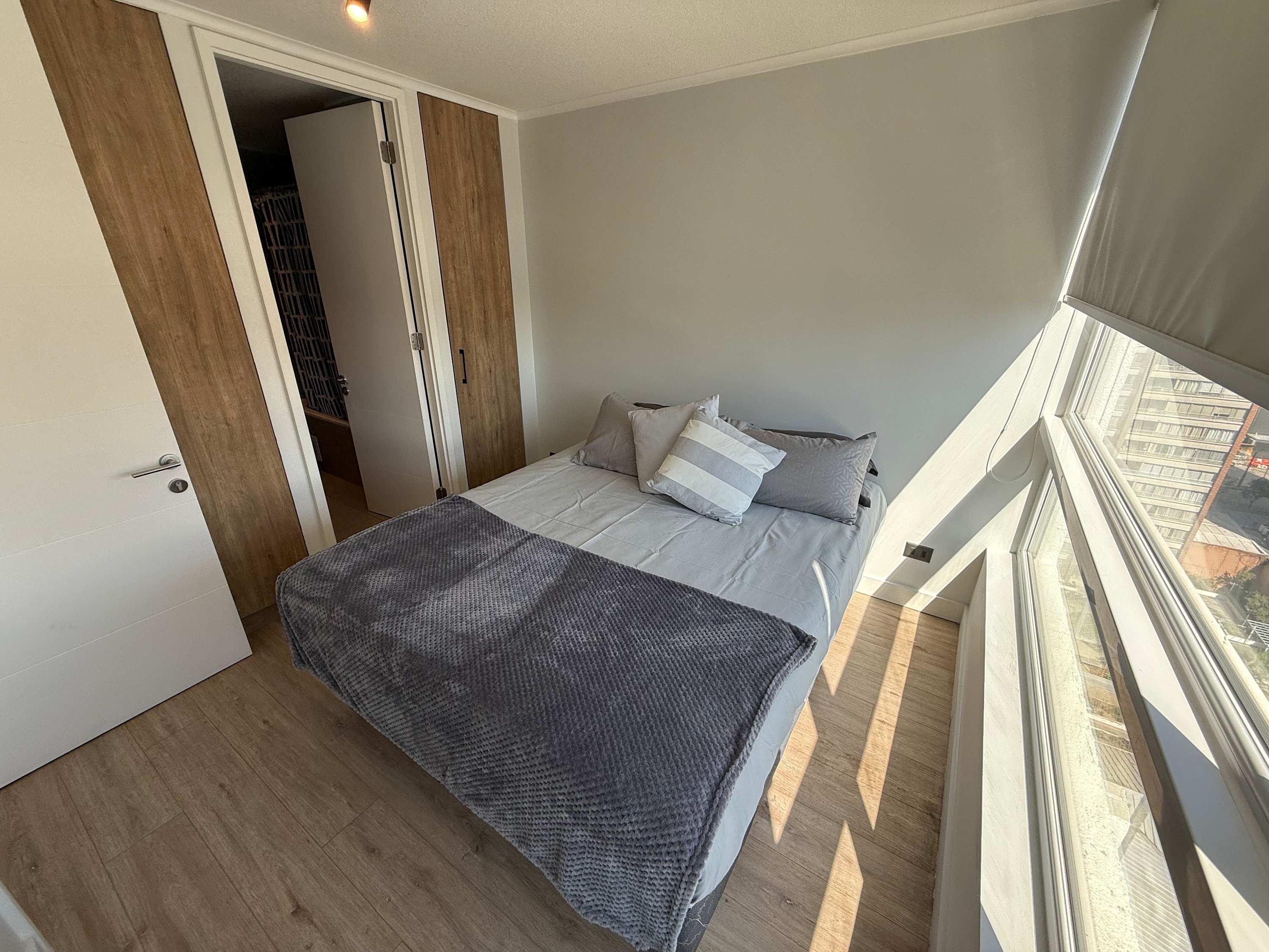 Bright and cozy bedroom with a large window offering stunning views, perfect for a relaxing stay.