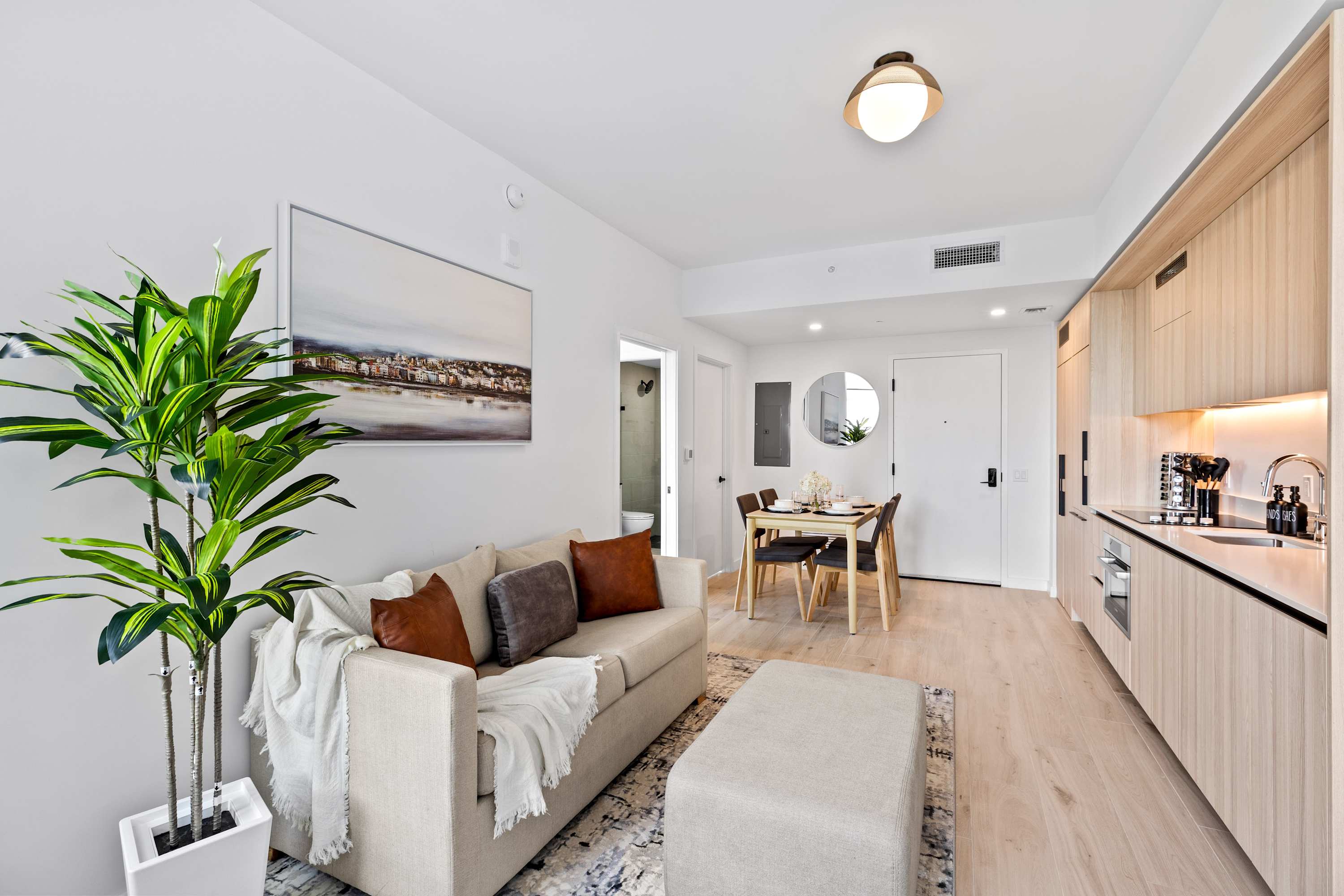 Cozy living space with sofa sleeper, kitchenette, and dining table