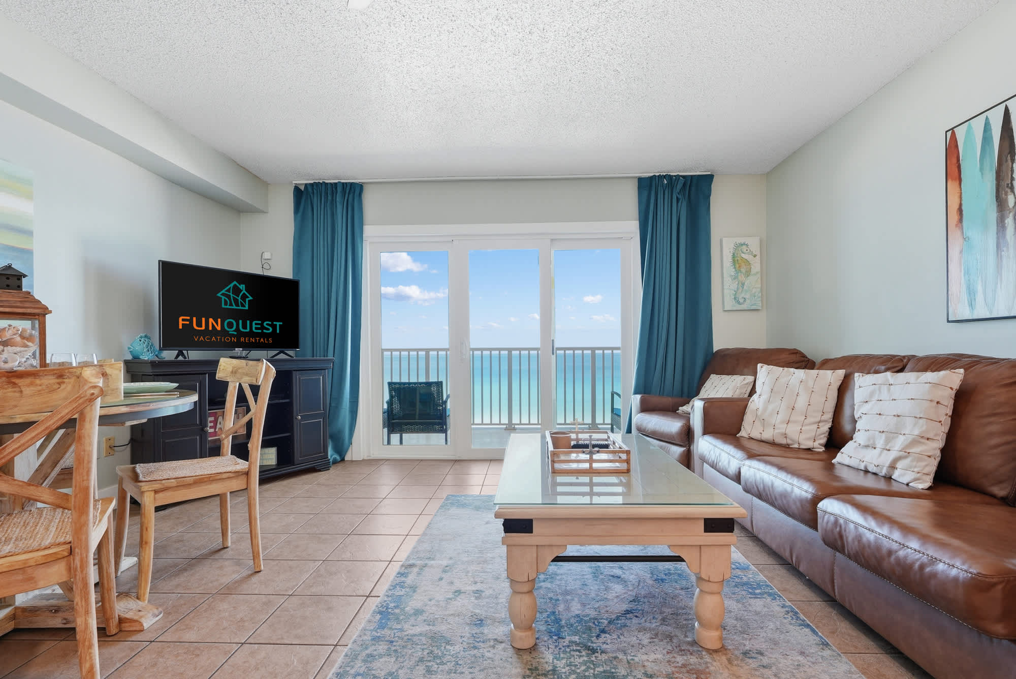 The Summit 921 – Living room with brown leather sofas, dining area, and balcony view of ocean.
