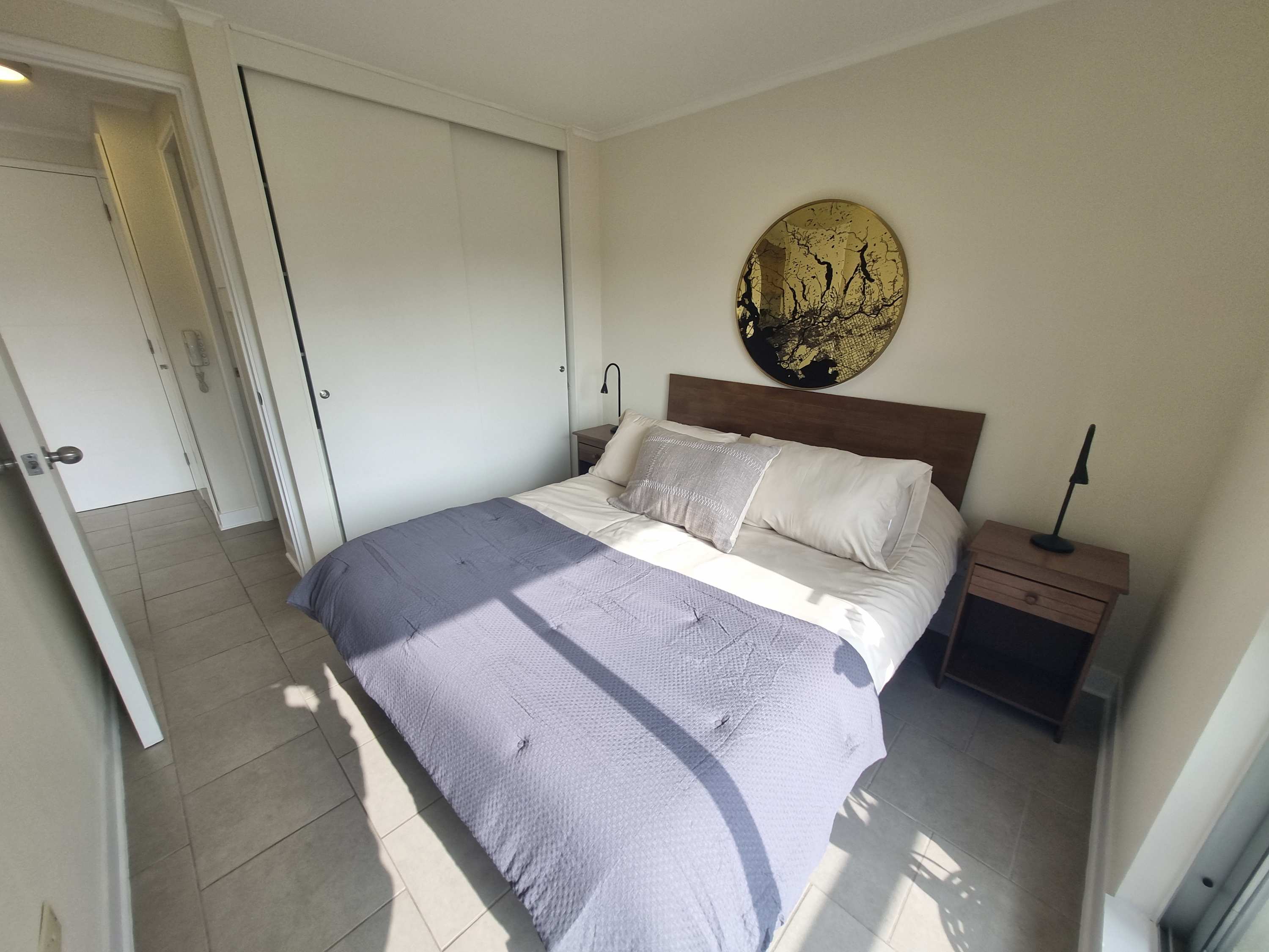 Relax in this cozy bedroom with natural light and stylish decor, perfect for a restful stay.