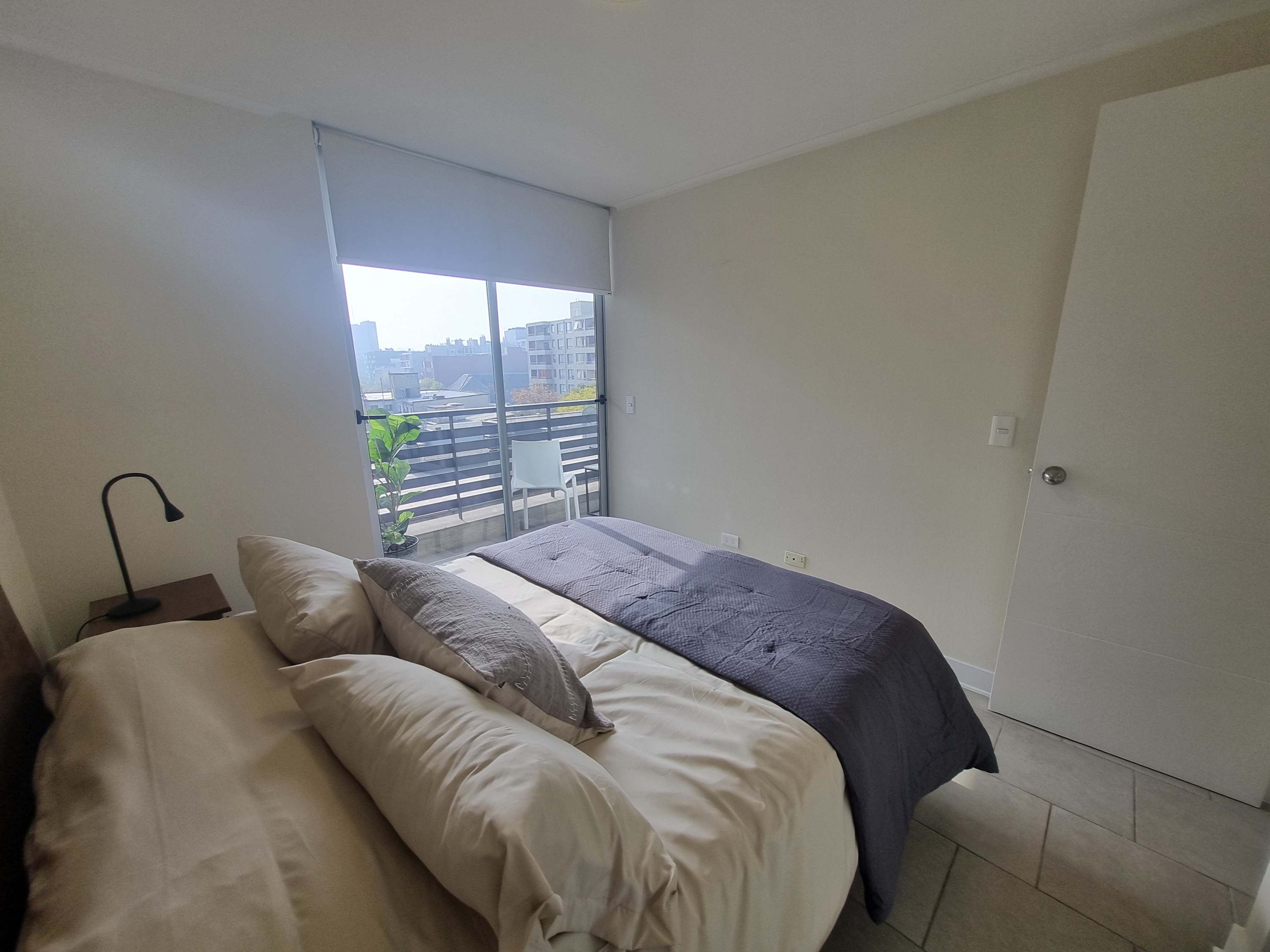 Relax in this cozy bedroom with natural light and a private balcony offering city views.