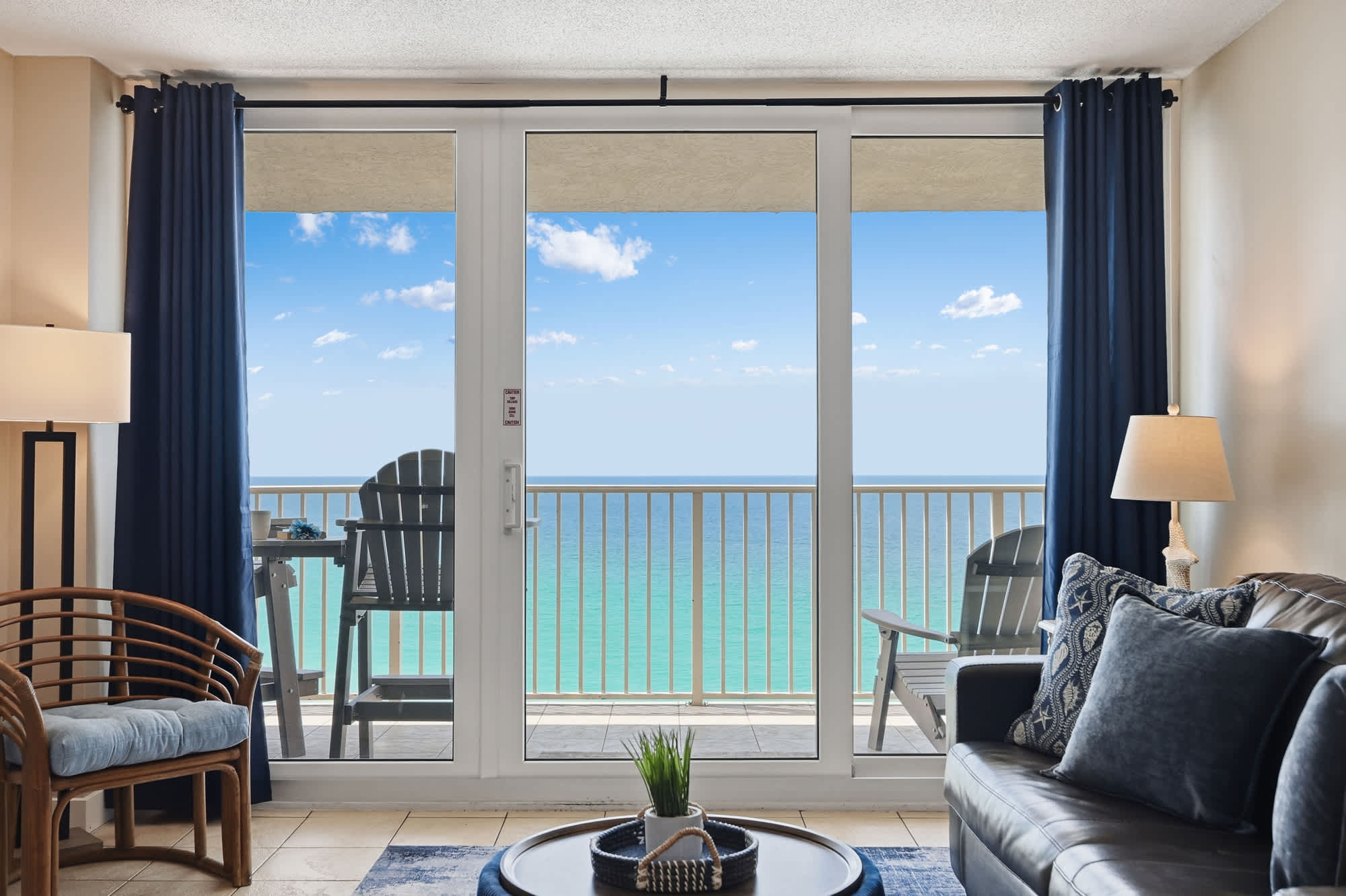 Dunes E1702 – Cozy living area with ocean view, balcony access, and modern furnishings.