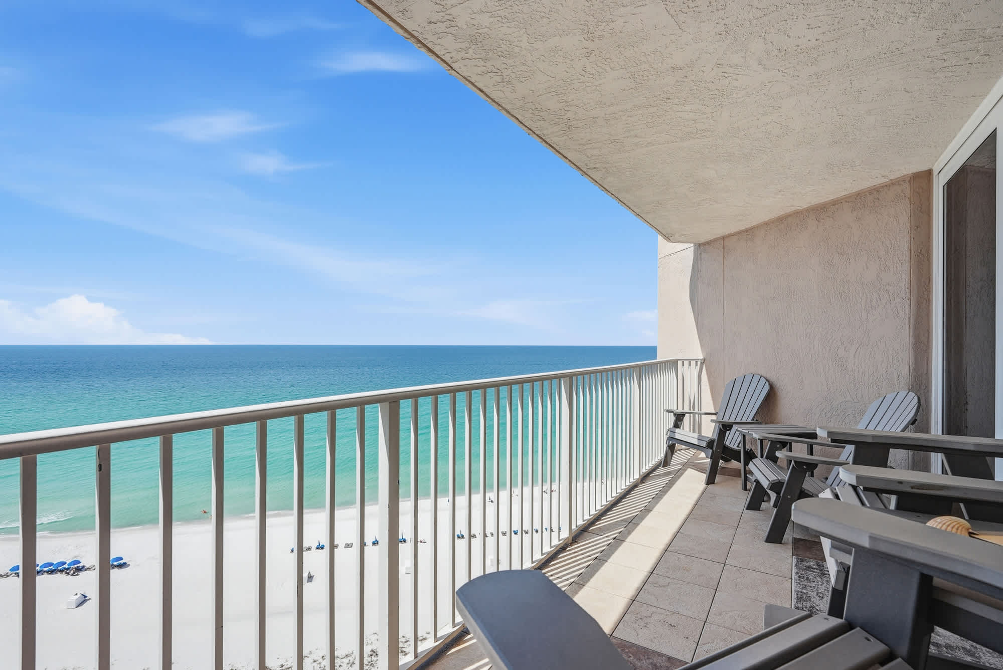 Dunes E1702 – Balcony view of the beach with seating and ocean in the background.