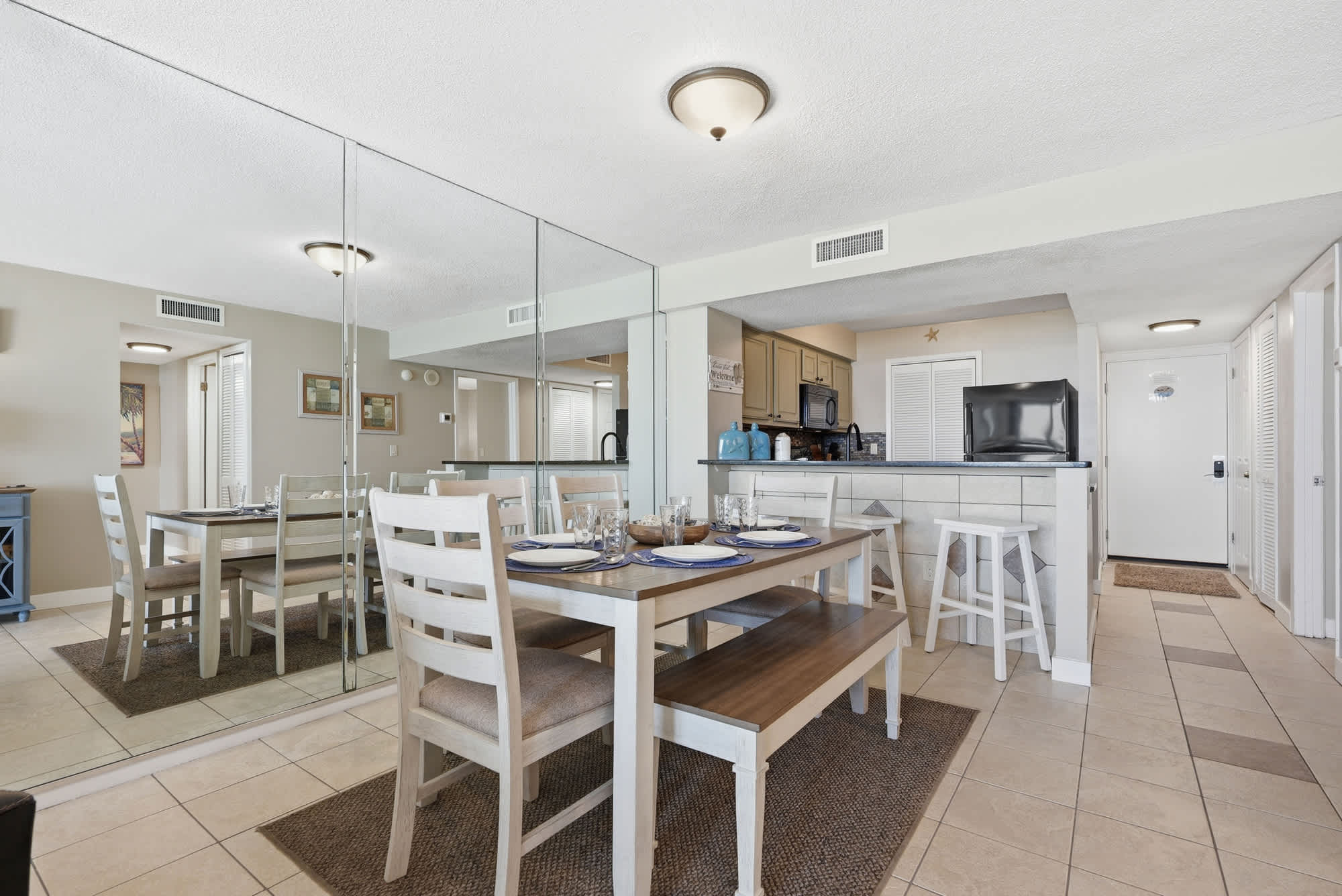 Dunes E1702 – Dining area with a table, chairs, and open kitchen view in a vacation rental.