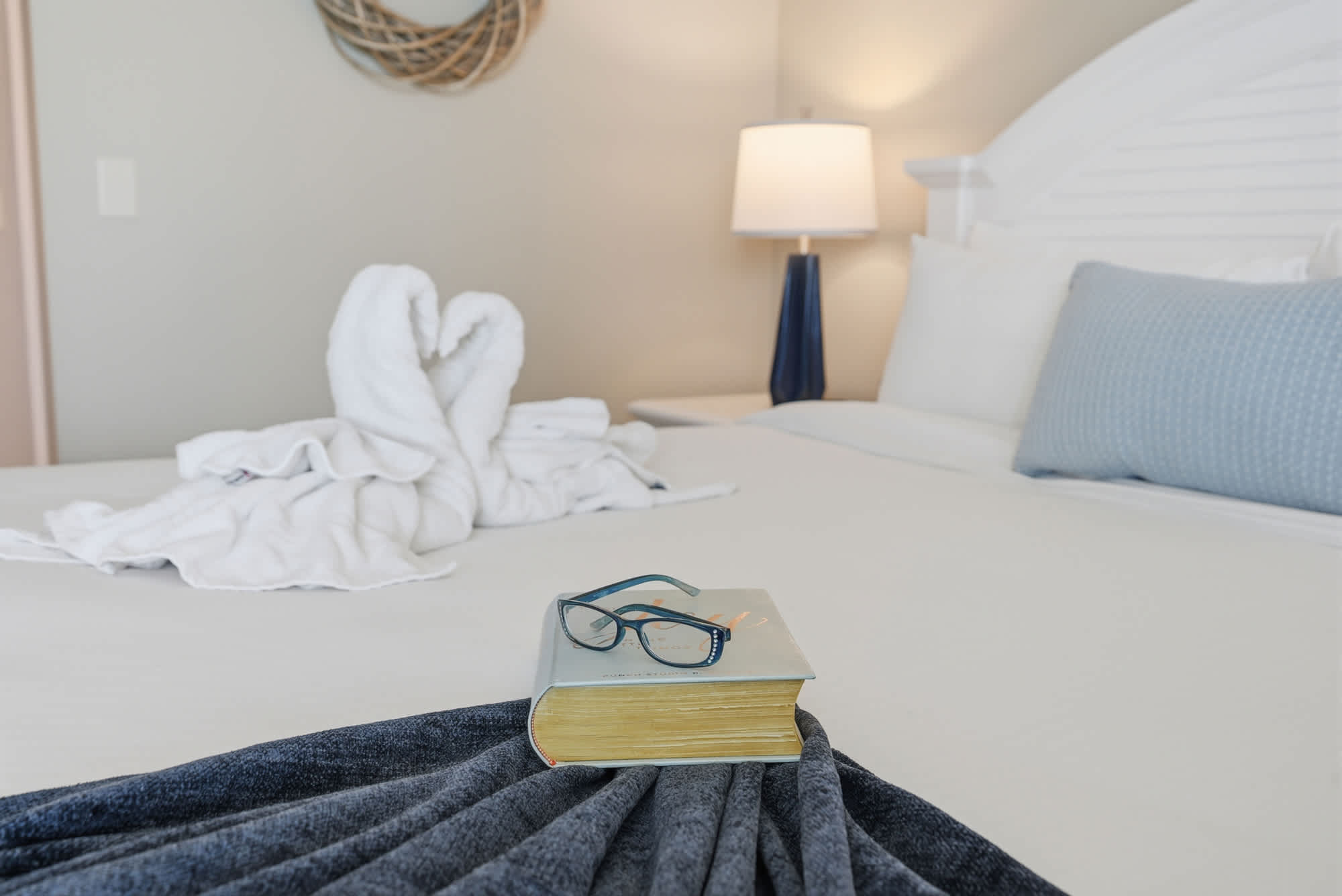Dunes E1702 – Cozy bedroom with a large bed, book, glasses, and towels arranged decoratively.