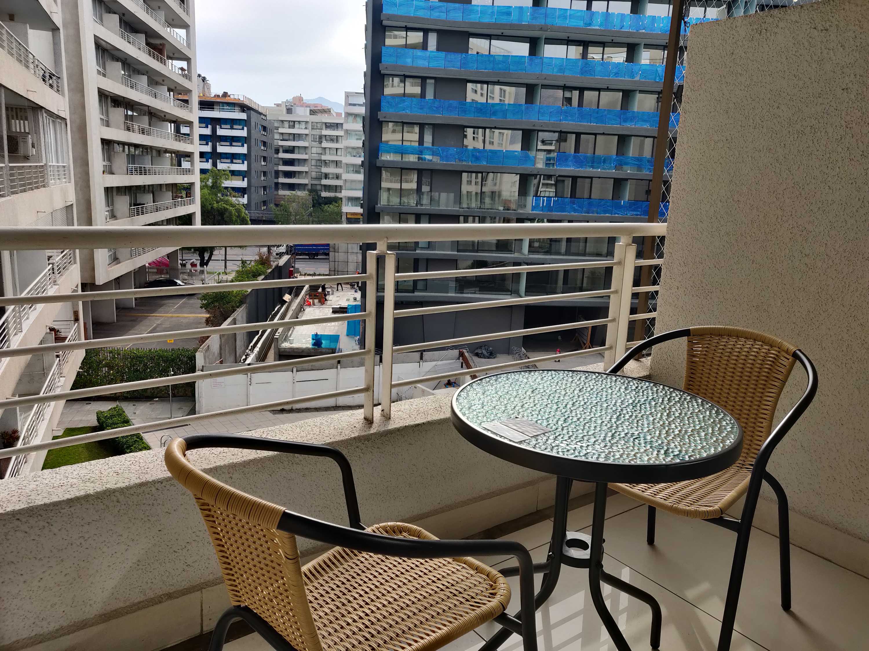 Enjoy your morning coffee on this cozy balcony with city views and a glimpse of the pool area.