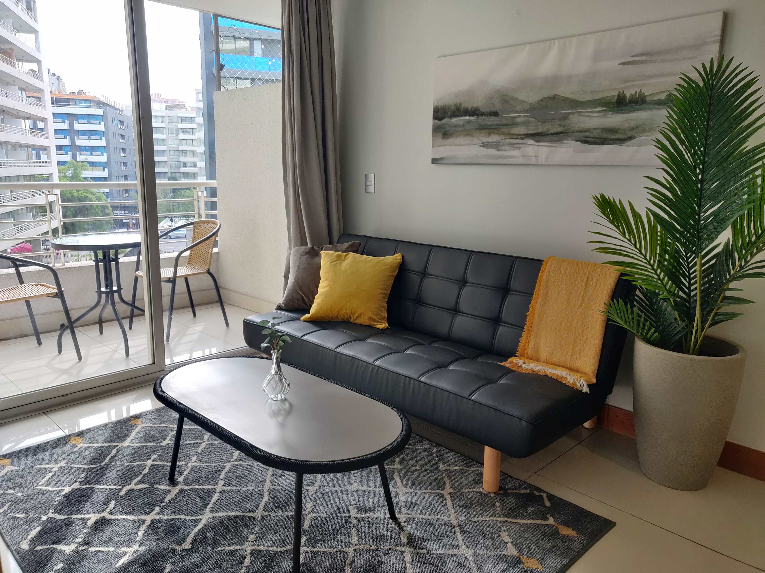 Relax in this stylish living area with a private balcony, perfect for enjoying city views and fresh air.