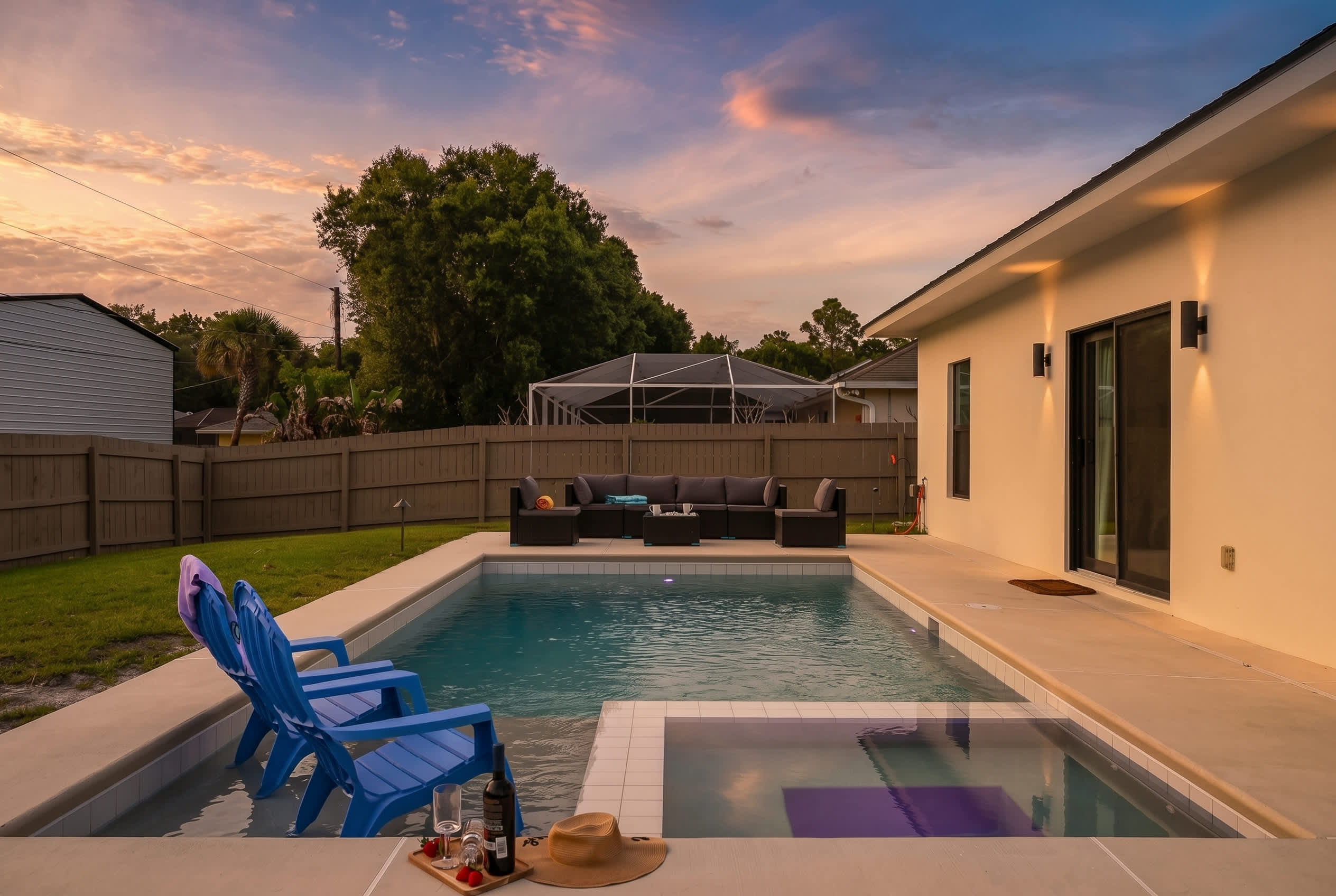 Relax by the modern pool with built-in seating and a spacious outdoor lounge area at sunset.