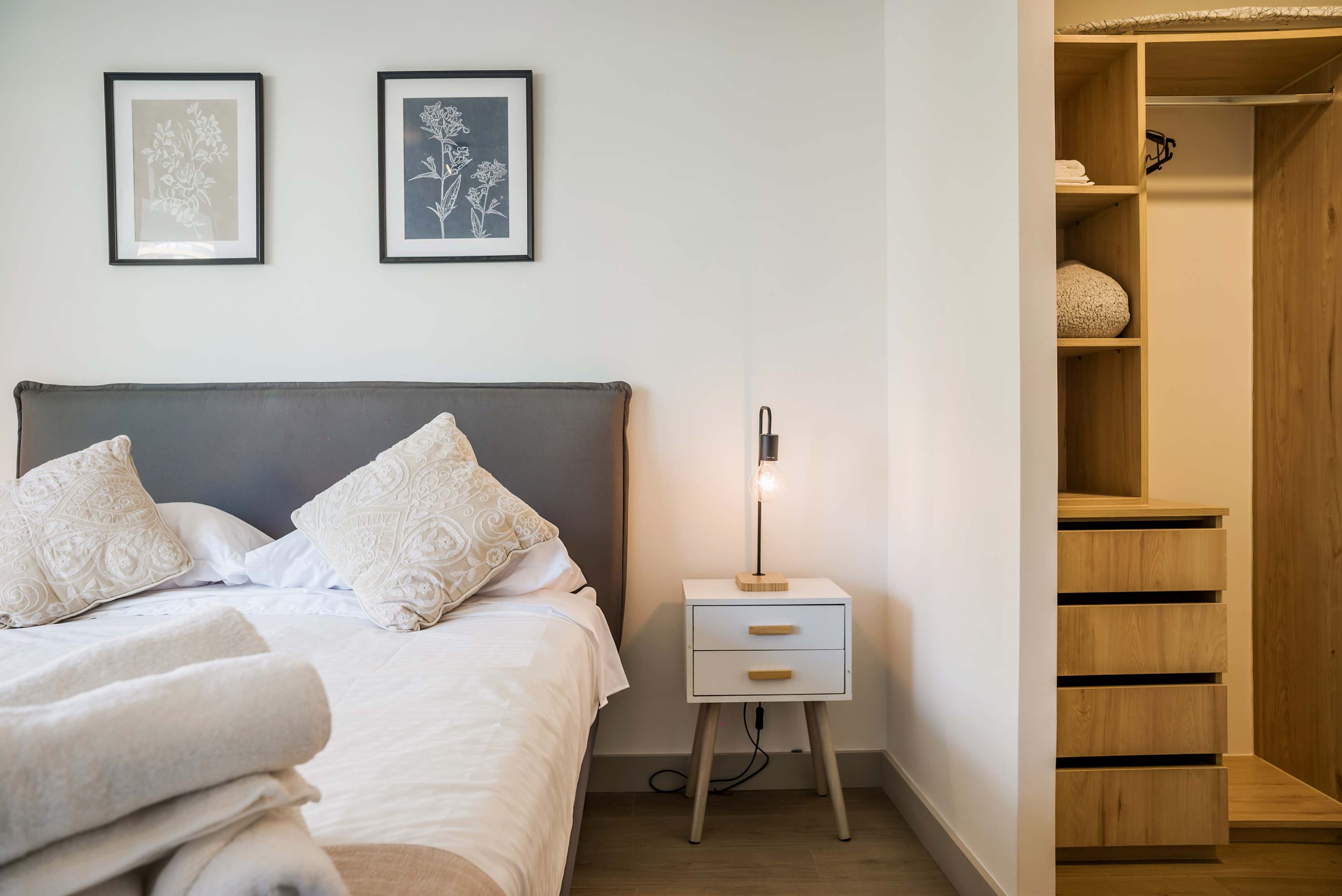 Relax in this stylish bedroom with modern decor and ample storage, perfect for a cozy stay.