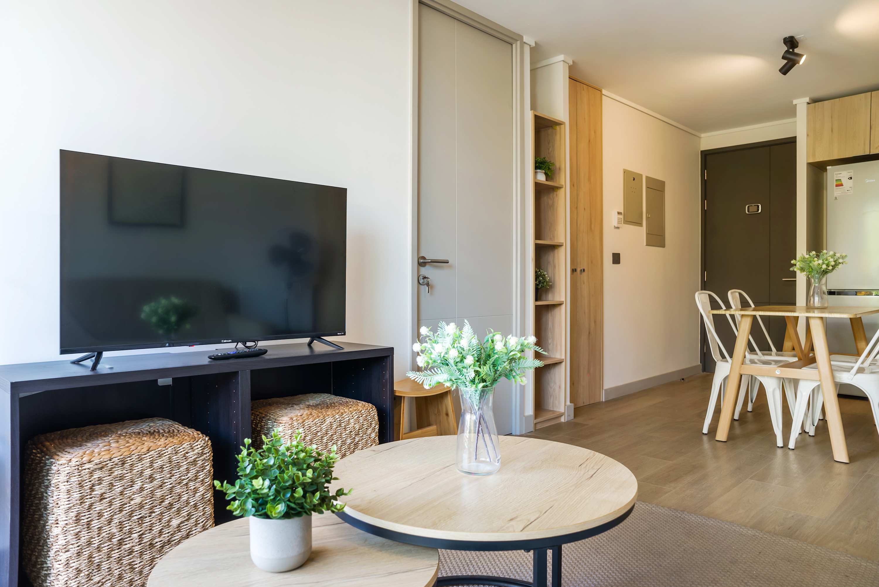 Cozy and modern living area with a flat-screen TV and stylish dining space, perfect for relaxing or entertaining.