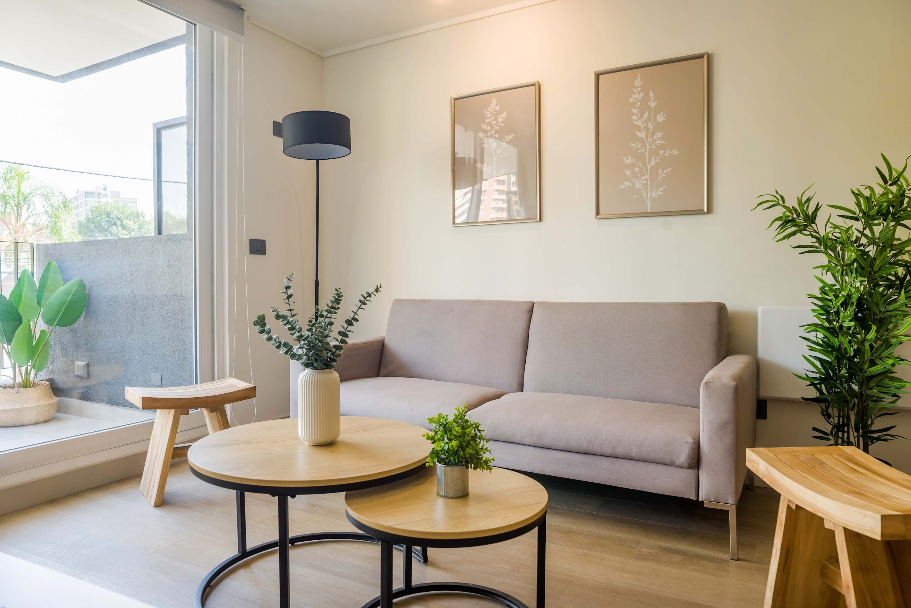 Cozy and bright living area with modern decor and a lush view, perfect for relaxation.