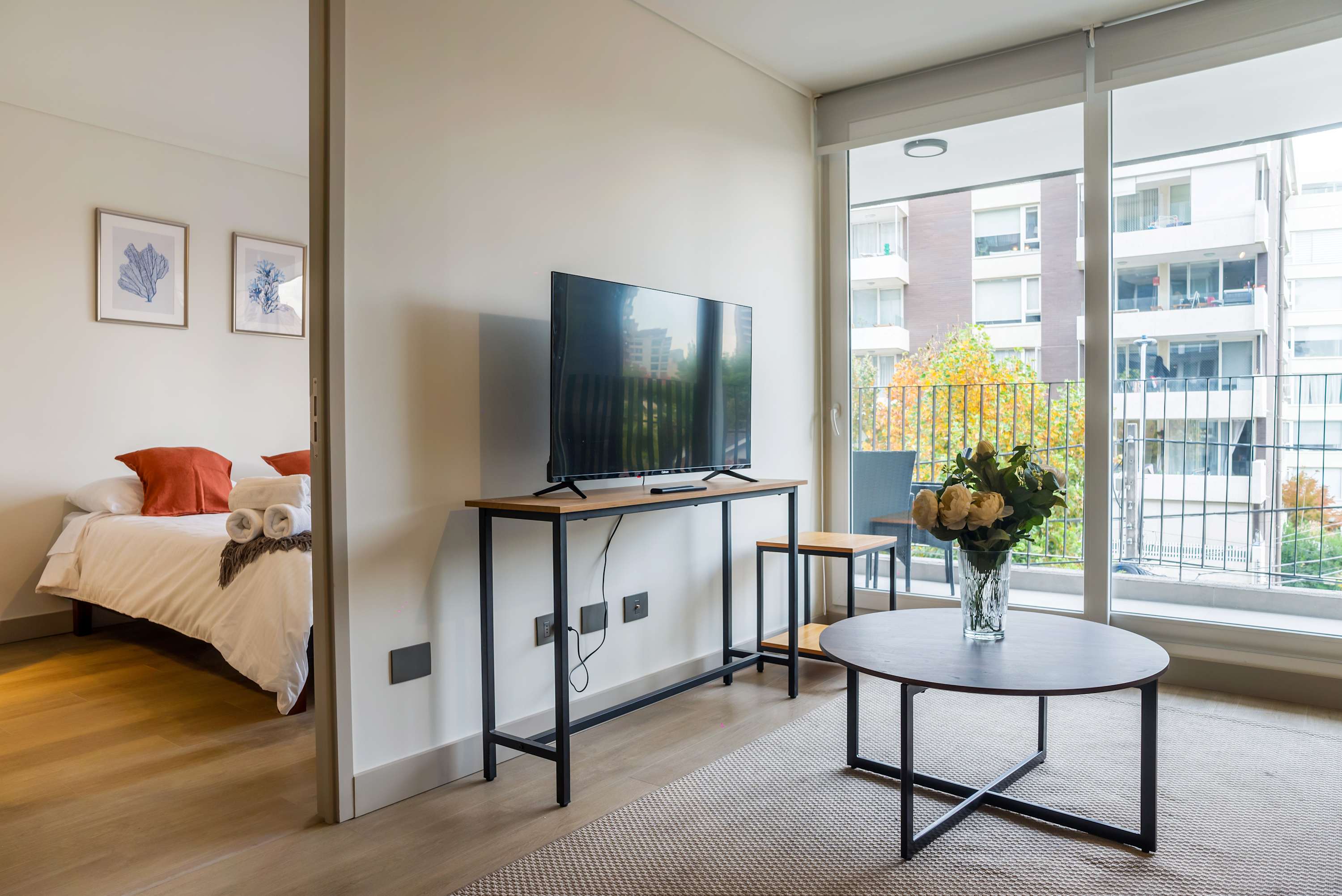 Cozy living area with modern amenities and a charming balcony view, perfect for relaxation.