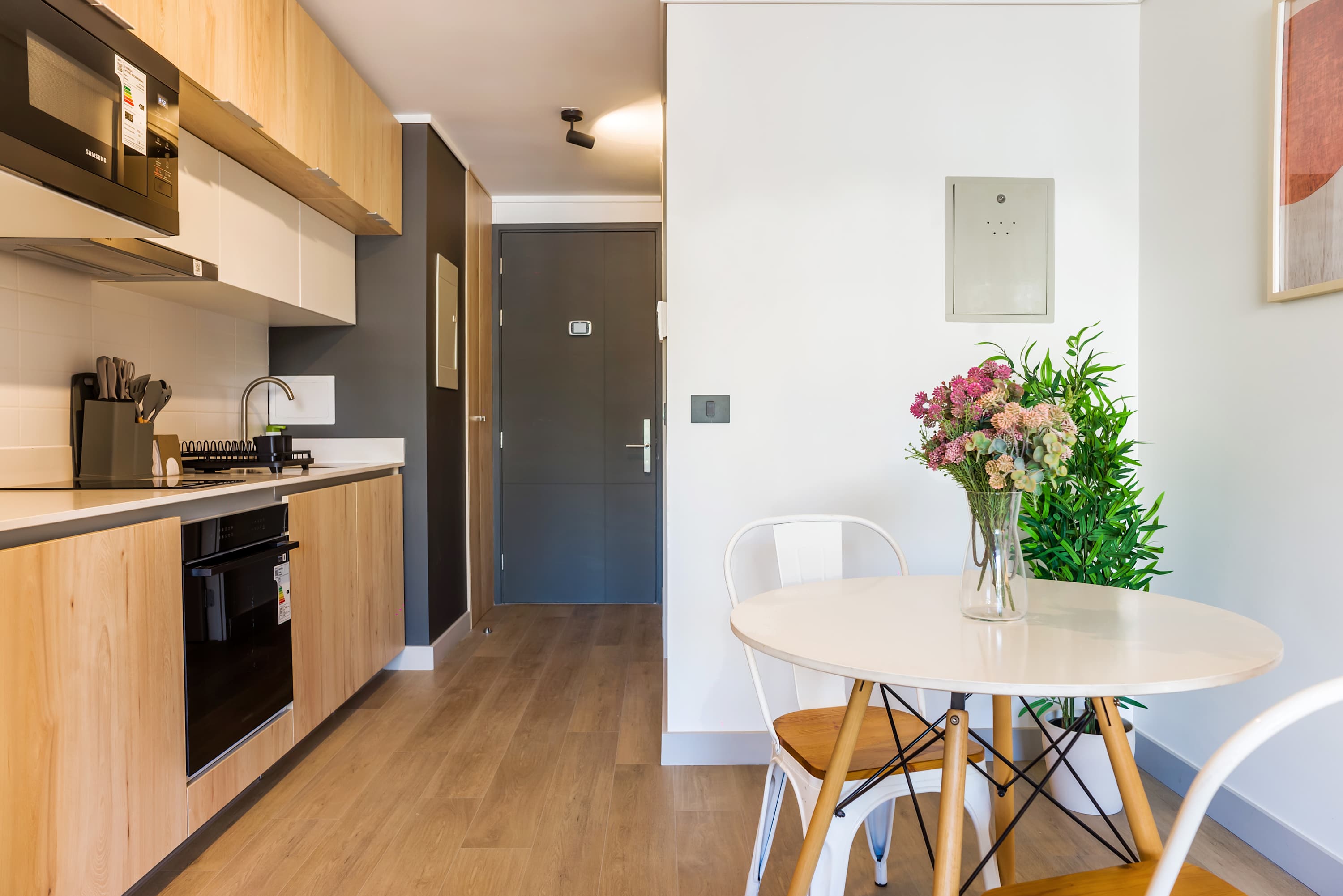 Charming studio kitchen with modern amenities and a cozy dining nook, perfect for intimate meals.