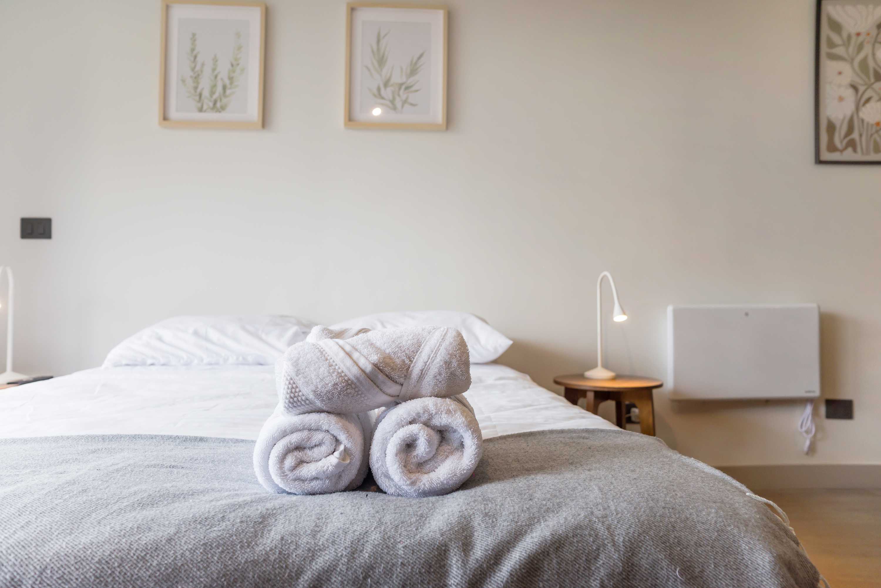 Cozy and inviting studio bedroom with plush bedding and modern decor, perfect for a relaxing stay.