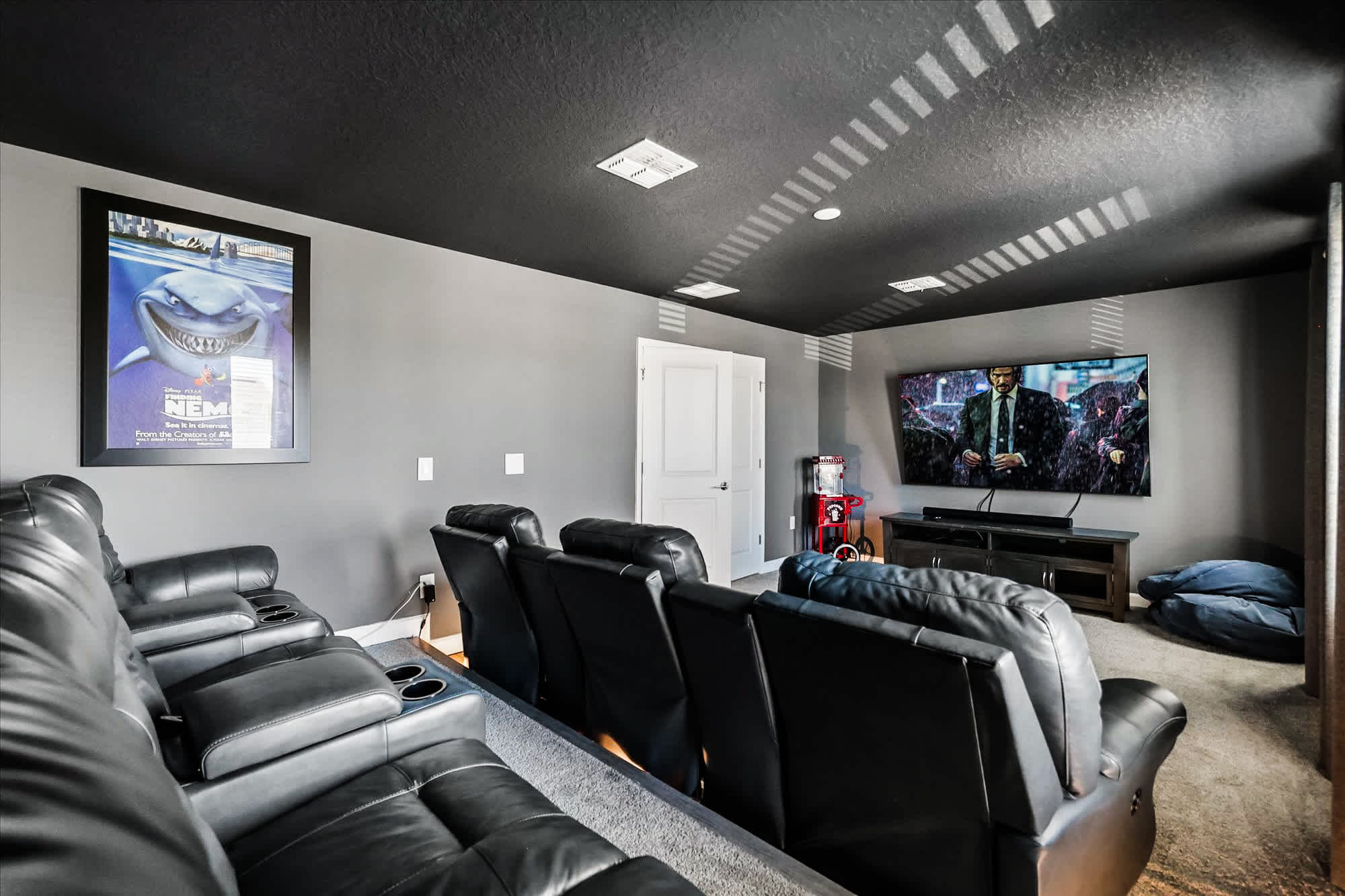Experience ultimate movie nights in your private home theater with luxurious recliners and a popcorn machine for a true cinematic feel.