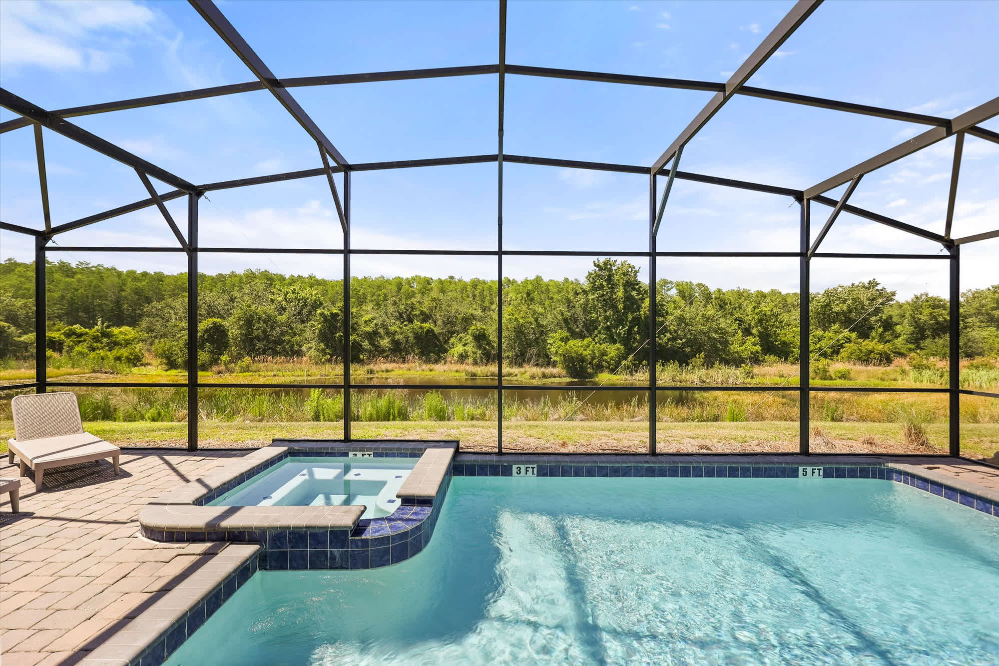 Relax in your private screened pool and hot tub, offering tranquil views of lush greenery and a serene escape.