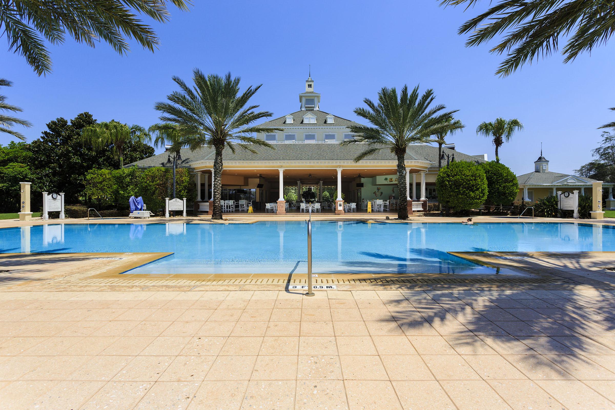 Seven Eagles clubhouse and pool with hot tubs, lounge seating, and a poolside tiki bar perfect for relaxing after the parks