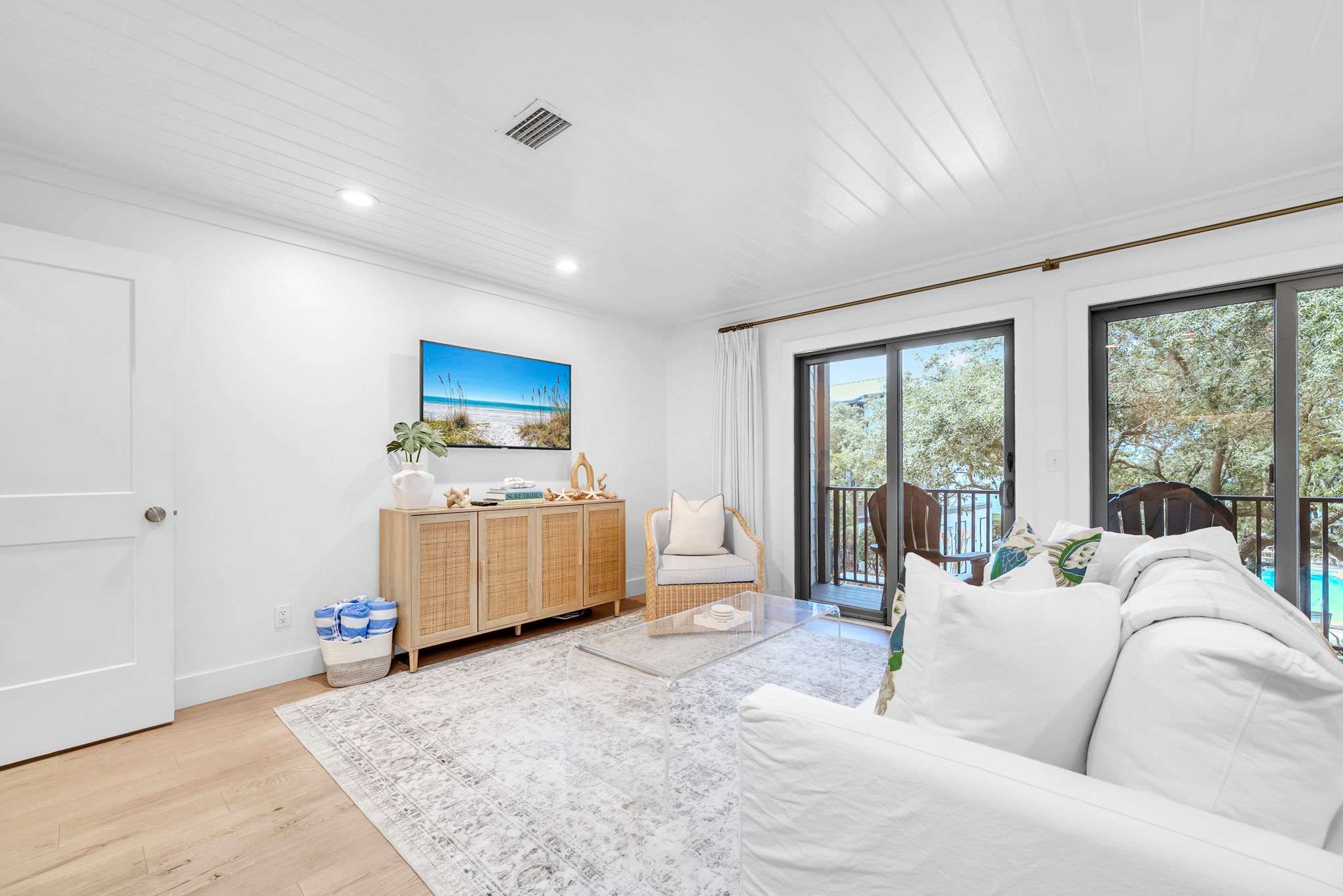 Living room features a sleeper sofa, smart tv, and access to balcony