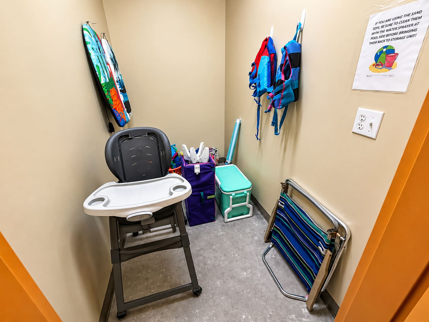 Splash 804E – Storage area with a high chair, beach gear, and life jackets on the wall.
