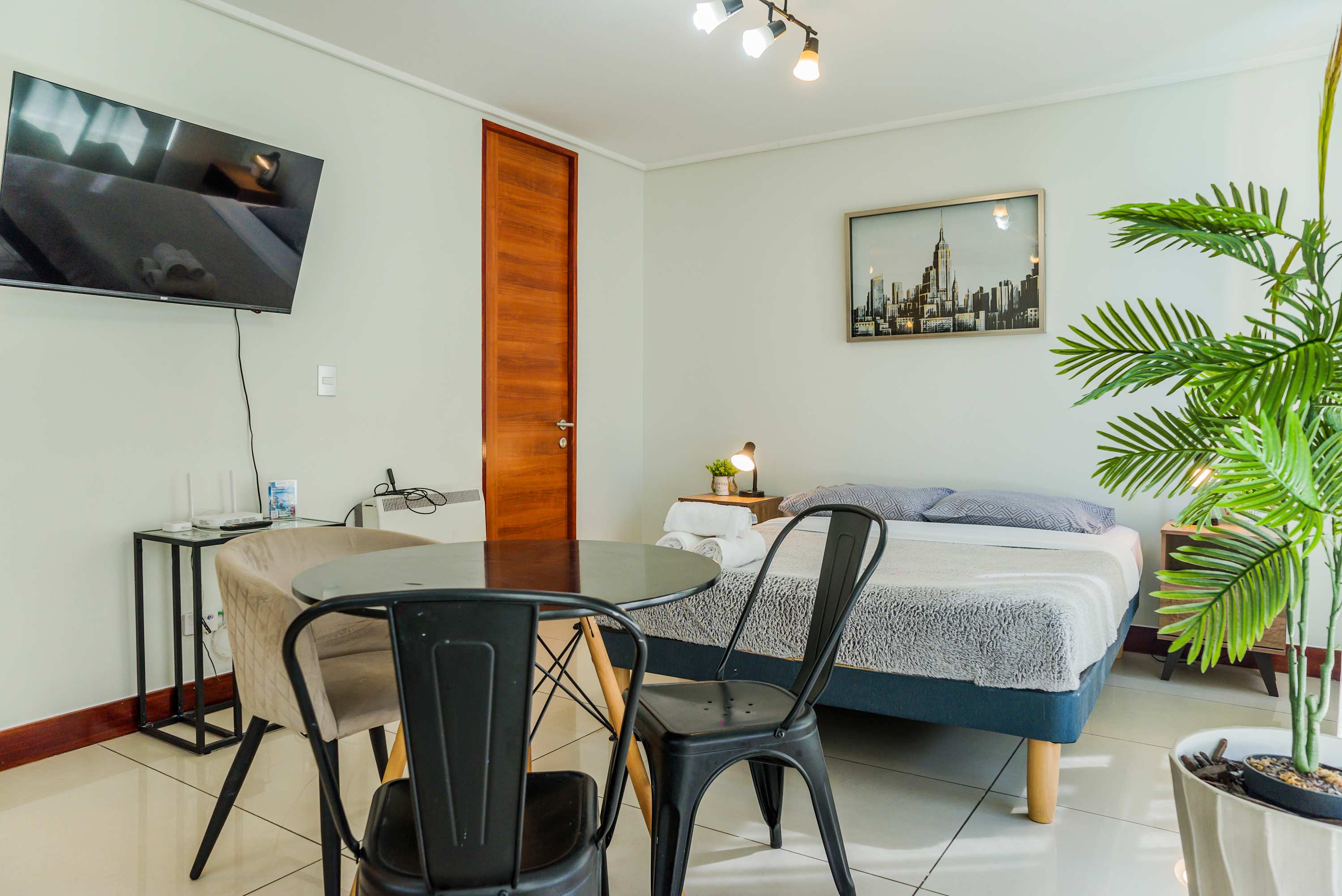 Cozy studio with modern decor, a comfy bed, and a dining area perfect for a relaxing stay.