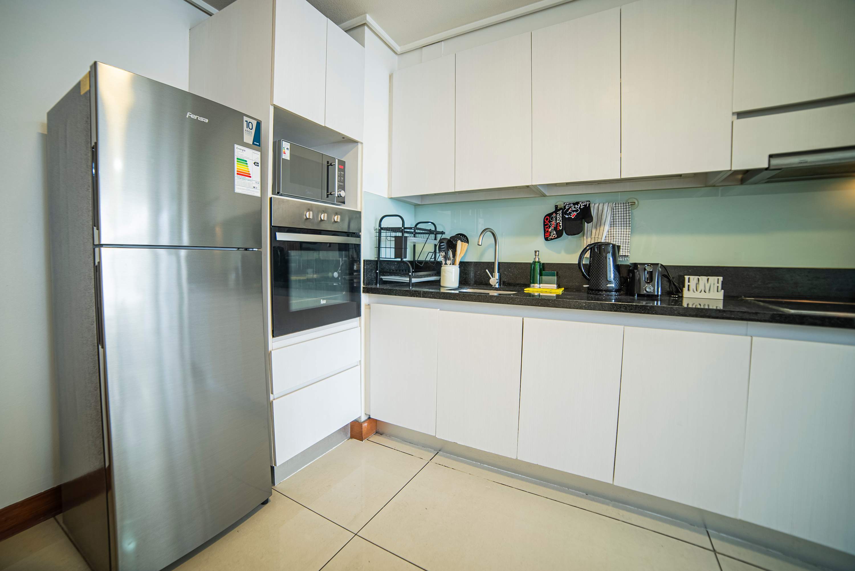 Sleek and modern kitchen with all essentials for a comfortable stay. Perfect for cooking your favorite meals.