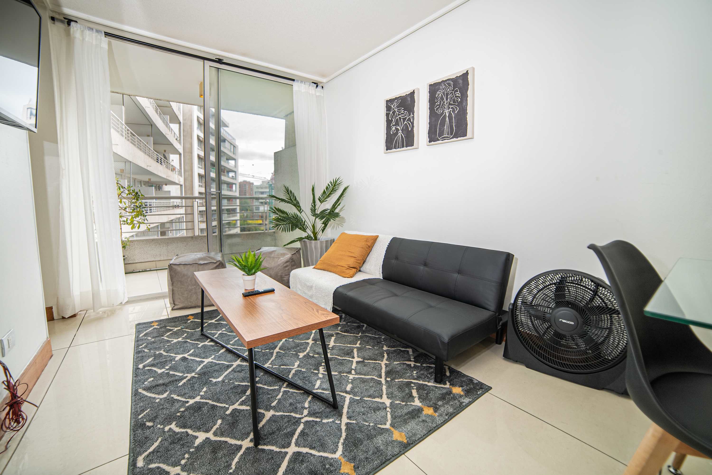 Bright and modern living space with a cozy sofa and balcony view, perfect for relaxing after a day exploring the city.