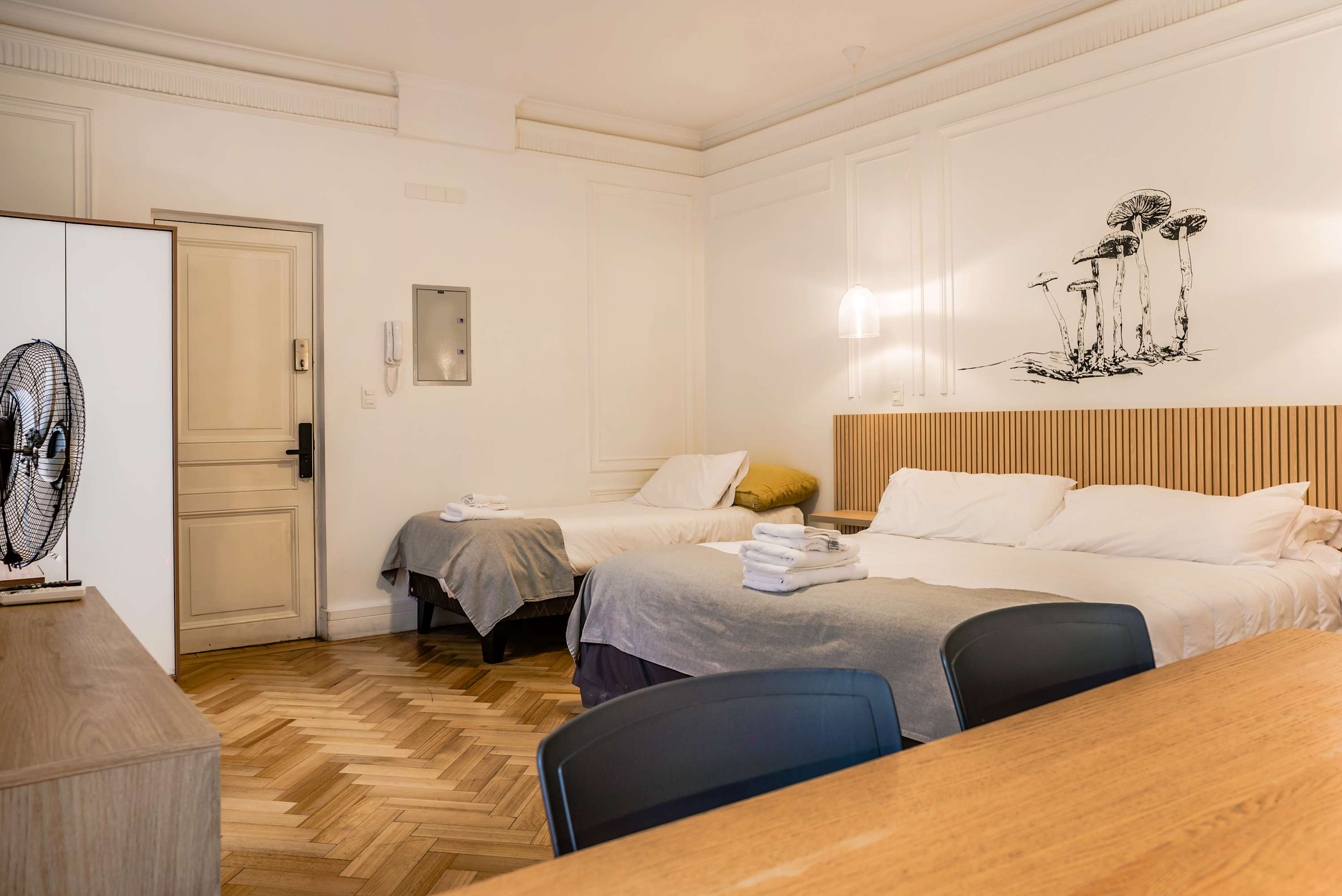Cozy studio with artistic wall mural and comfortable bedding, perfect for a relaxing stay.