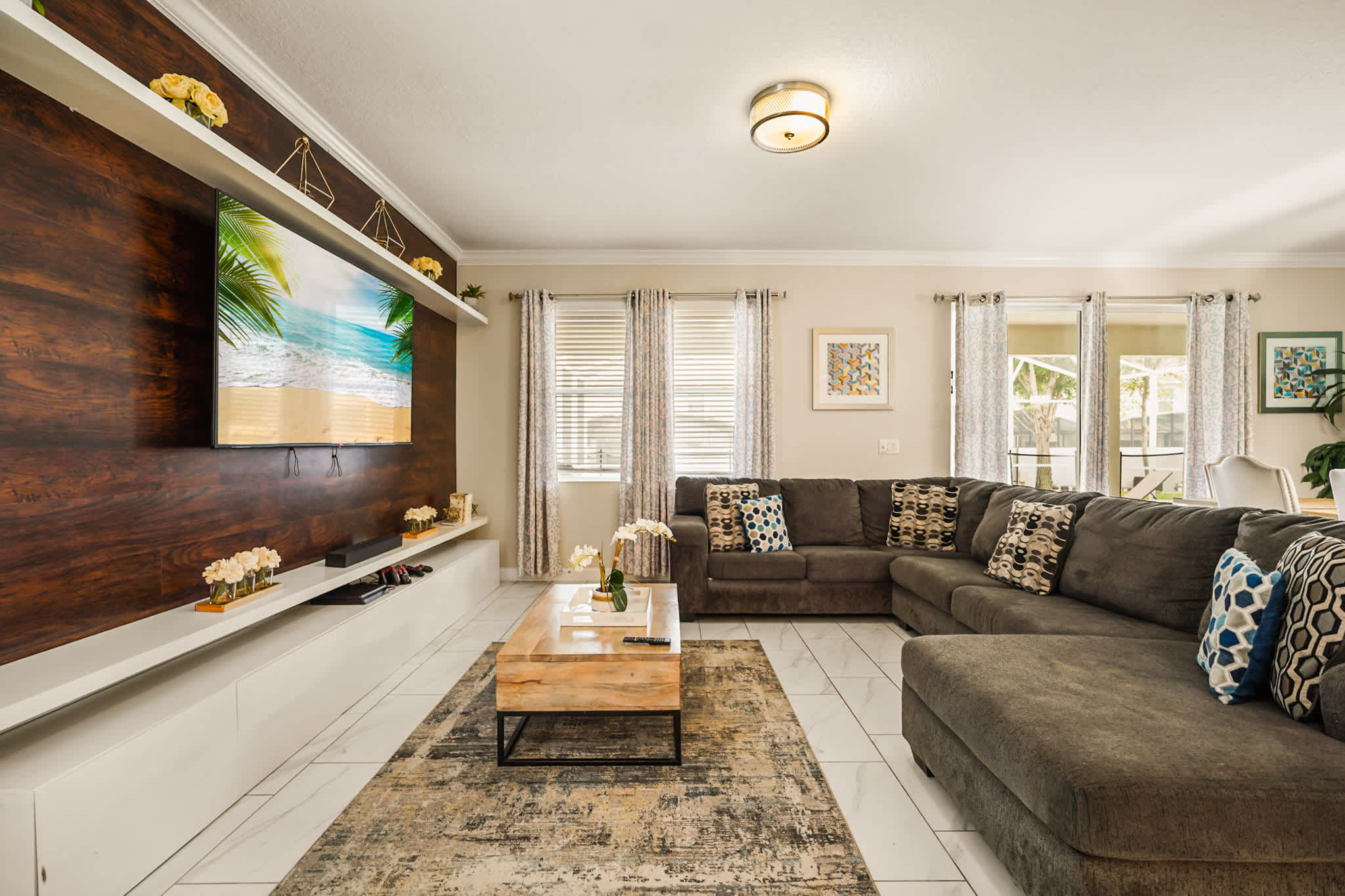 Relax in this spacious living room featuring a cozy sectional sofa and a large TV, perfect for family gatherings.