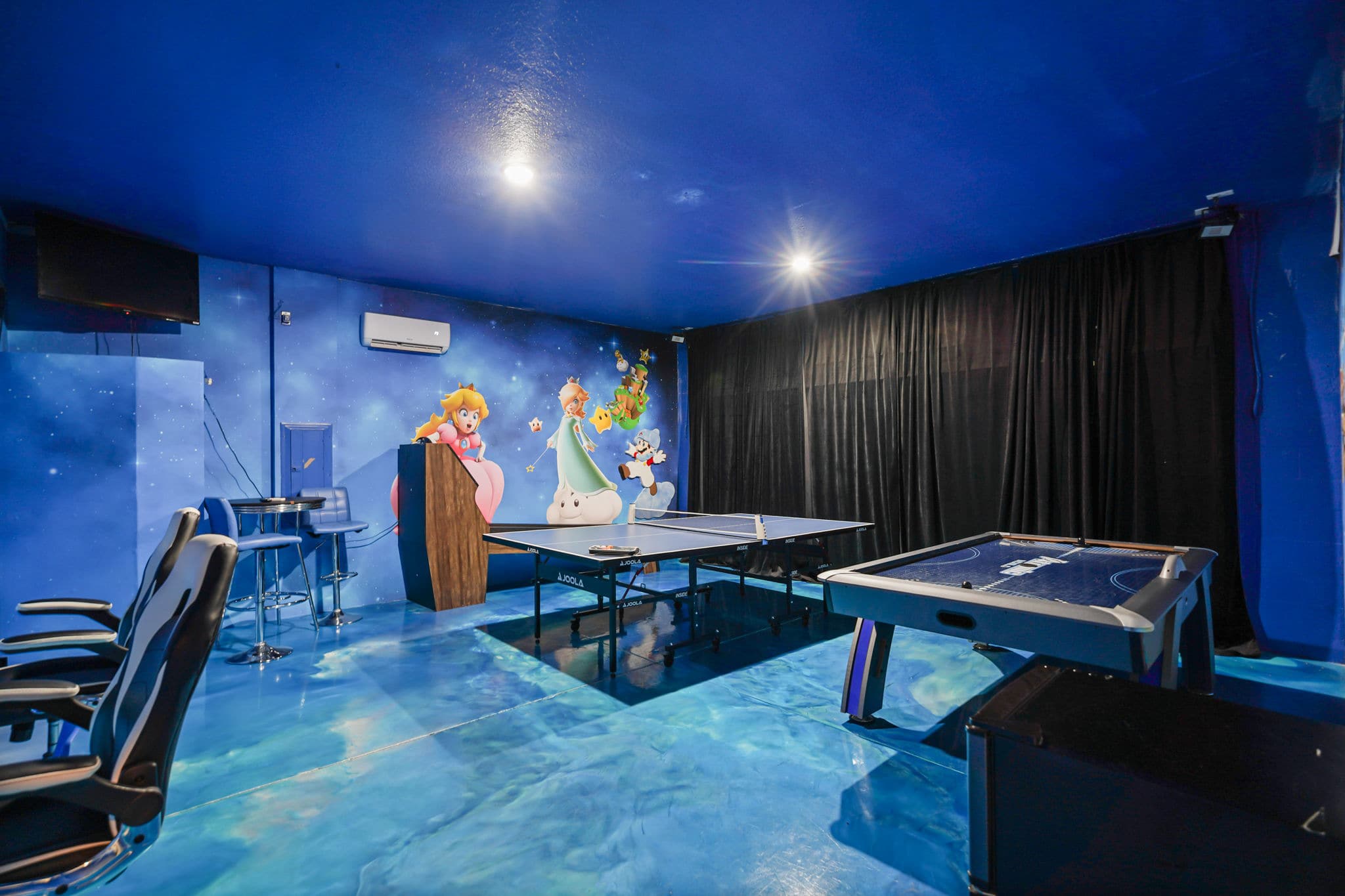 Experience endless fun in this vibrant game room with ping pong and air hockey tables, perfect for family entertainment.