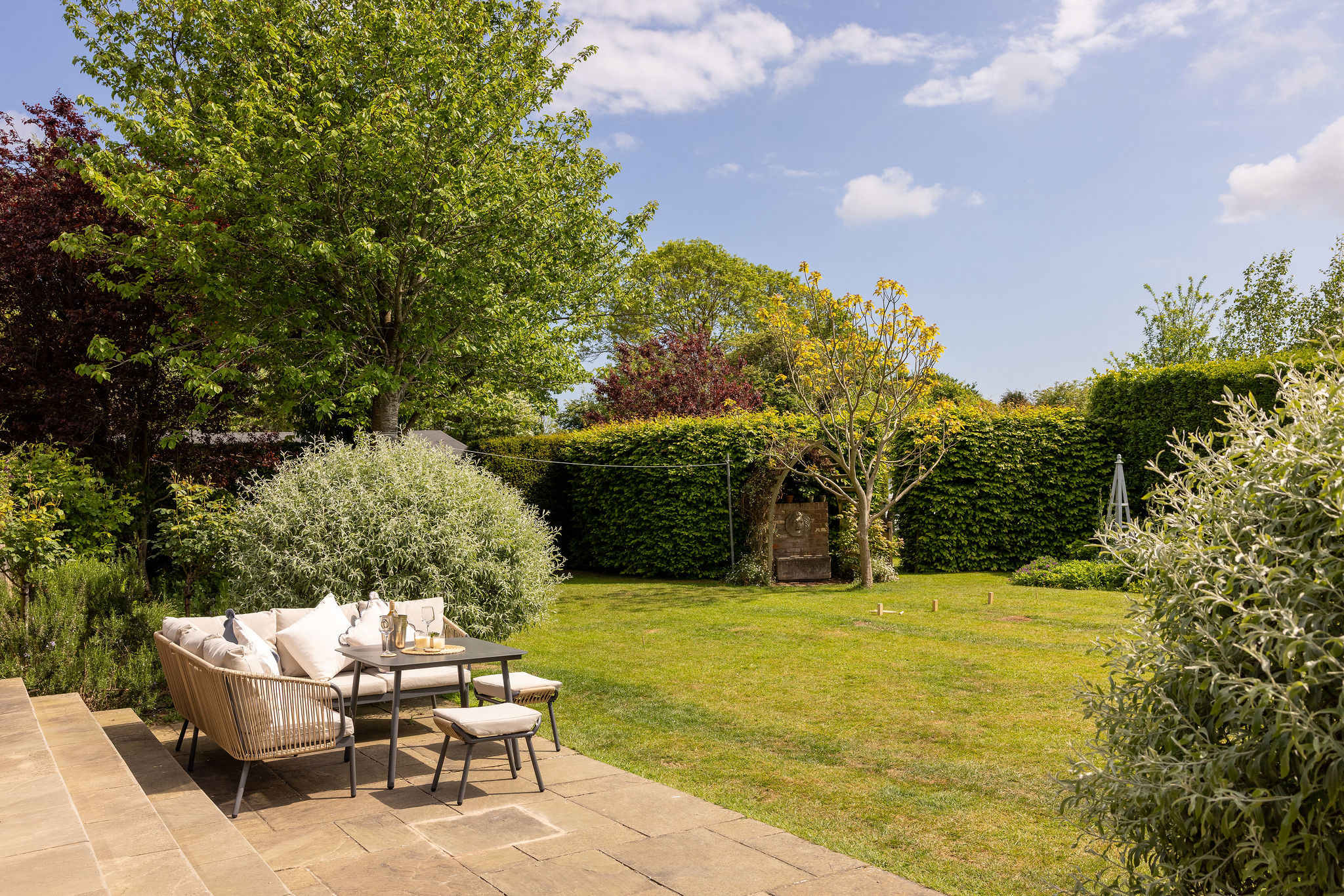 Peaceful outdoor seating area surrounded by mature gardens.
