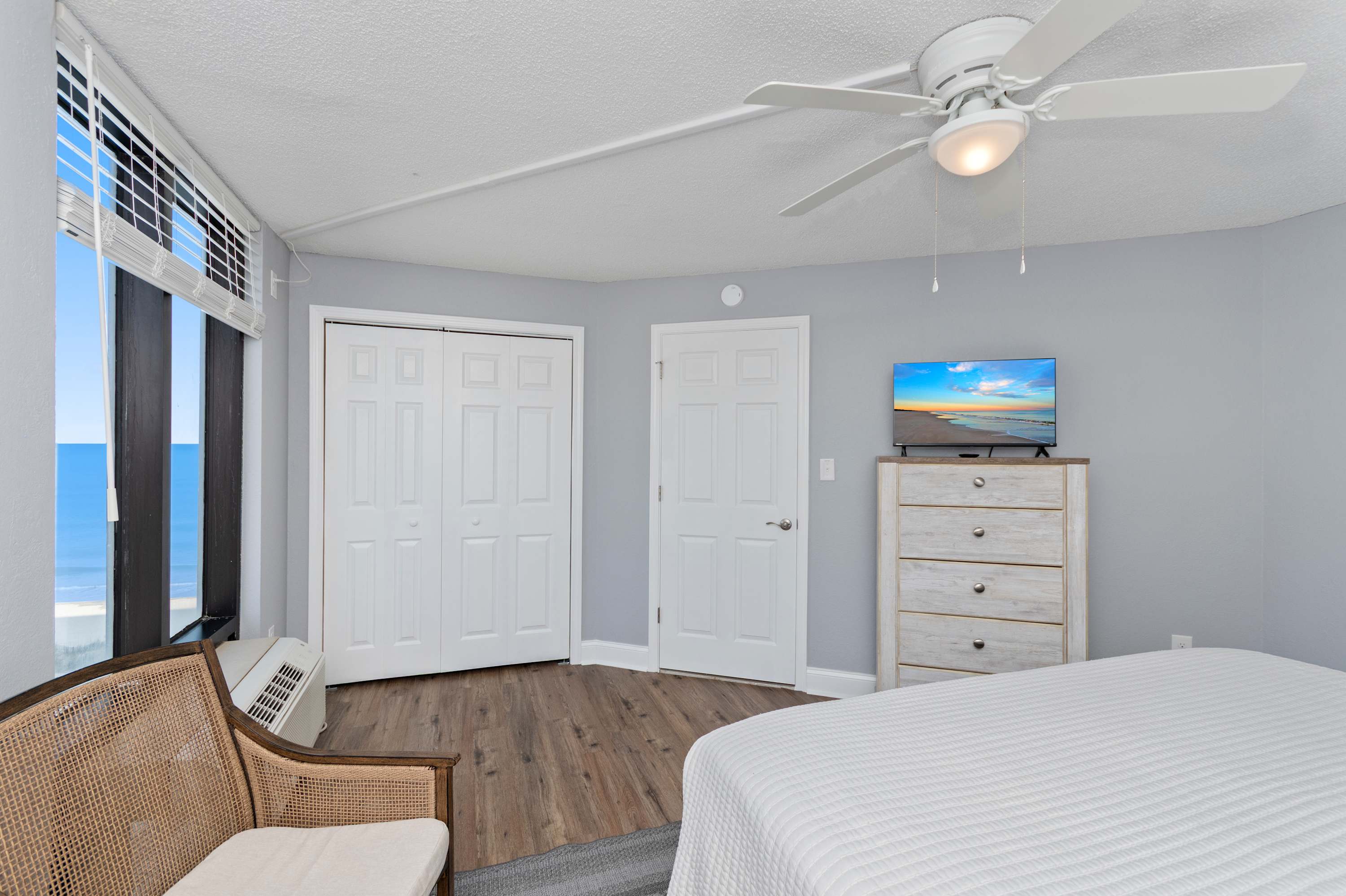 Relax and recharge in a stylish bedroom featuring natural light, comfortable bedding, and a calming coastal vibe.