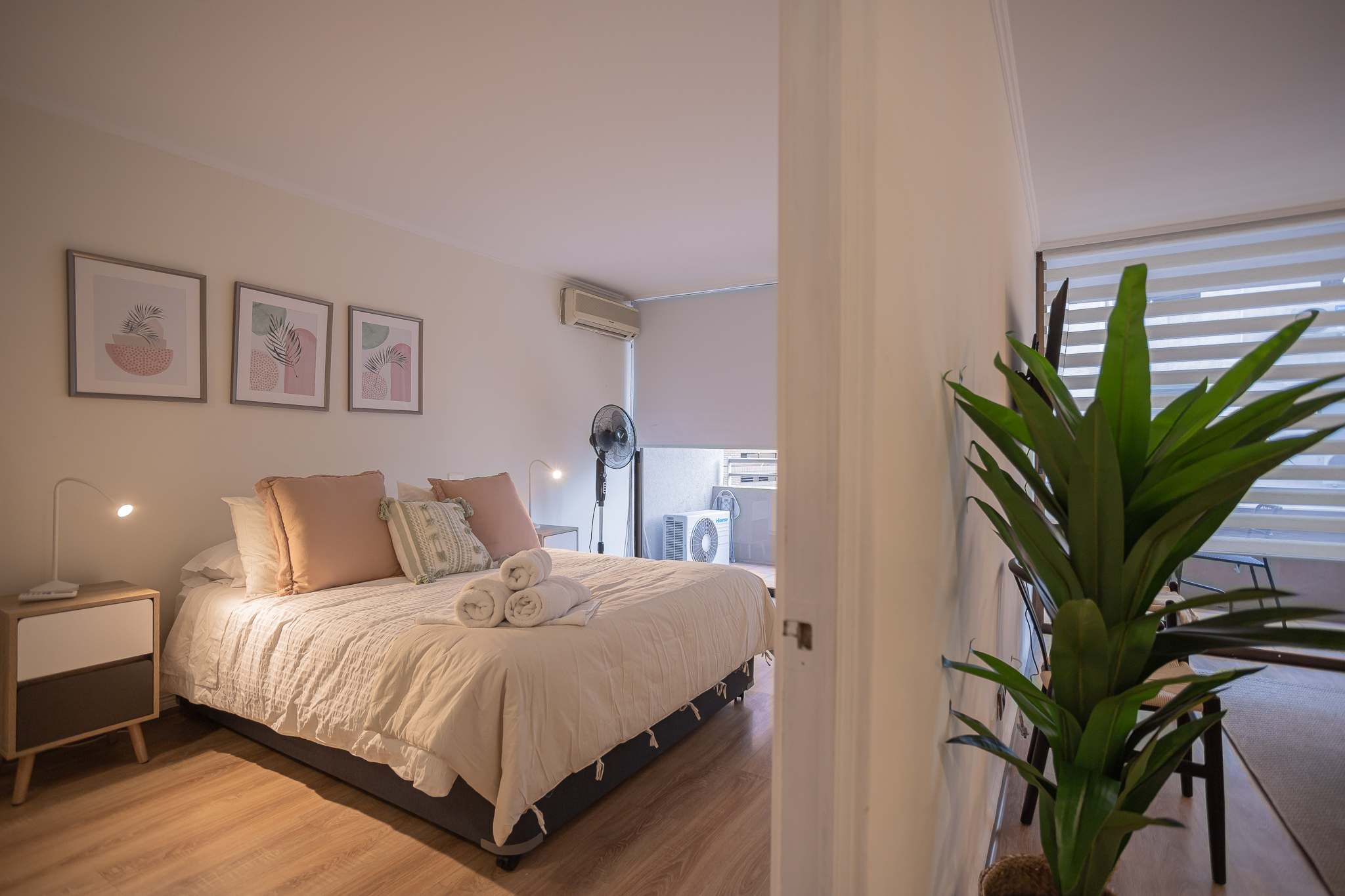 Relax in this cozy and stylish bedroom with modern decor and a touch of greenery, perfect for a restful stay in the heart of Chile.