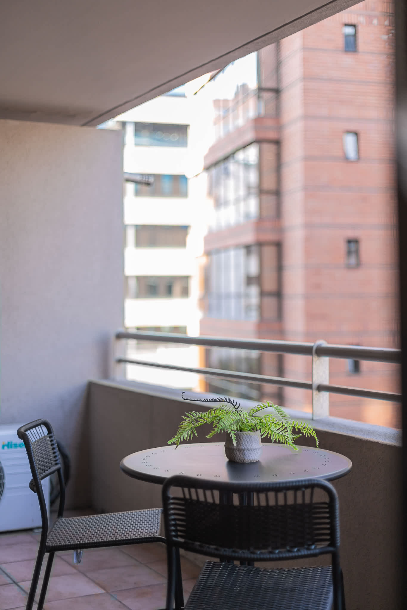 Cozy private balcony with seating and city views, perfect for a morning coffee or evening relaxation.