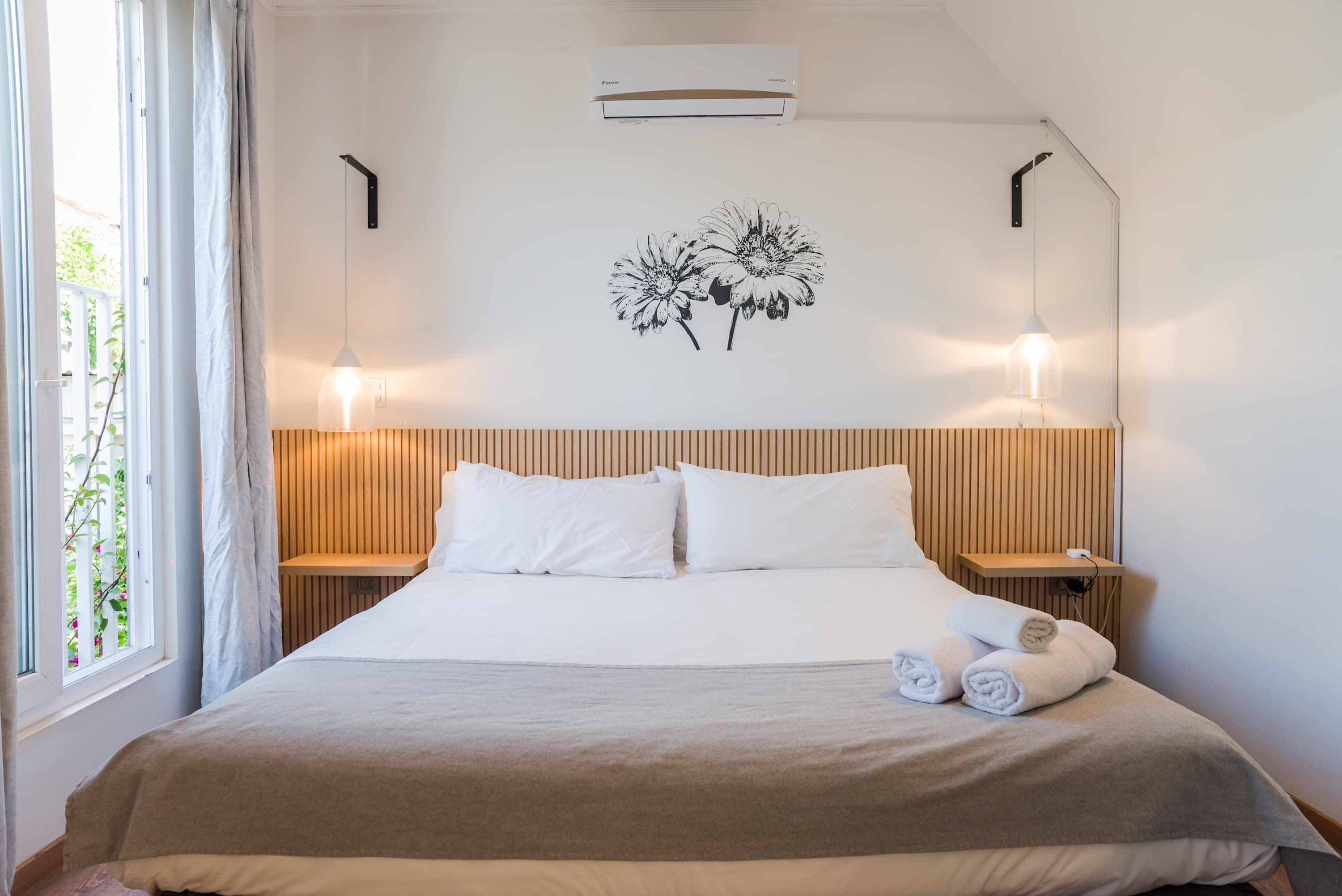 Relax in this bright and airy bedroom with a comfortable bed and modern decor, perfect for a restful stay.