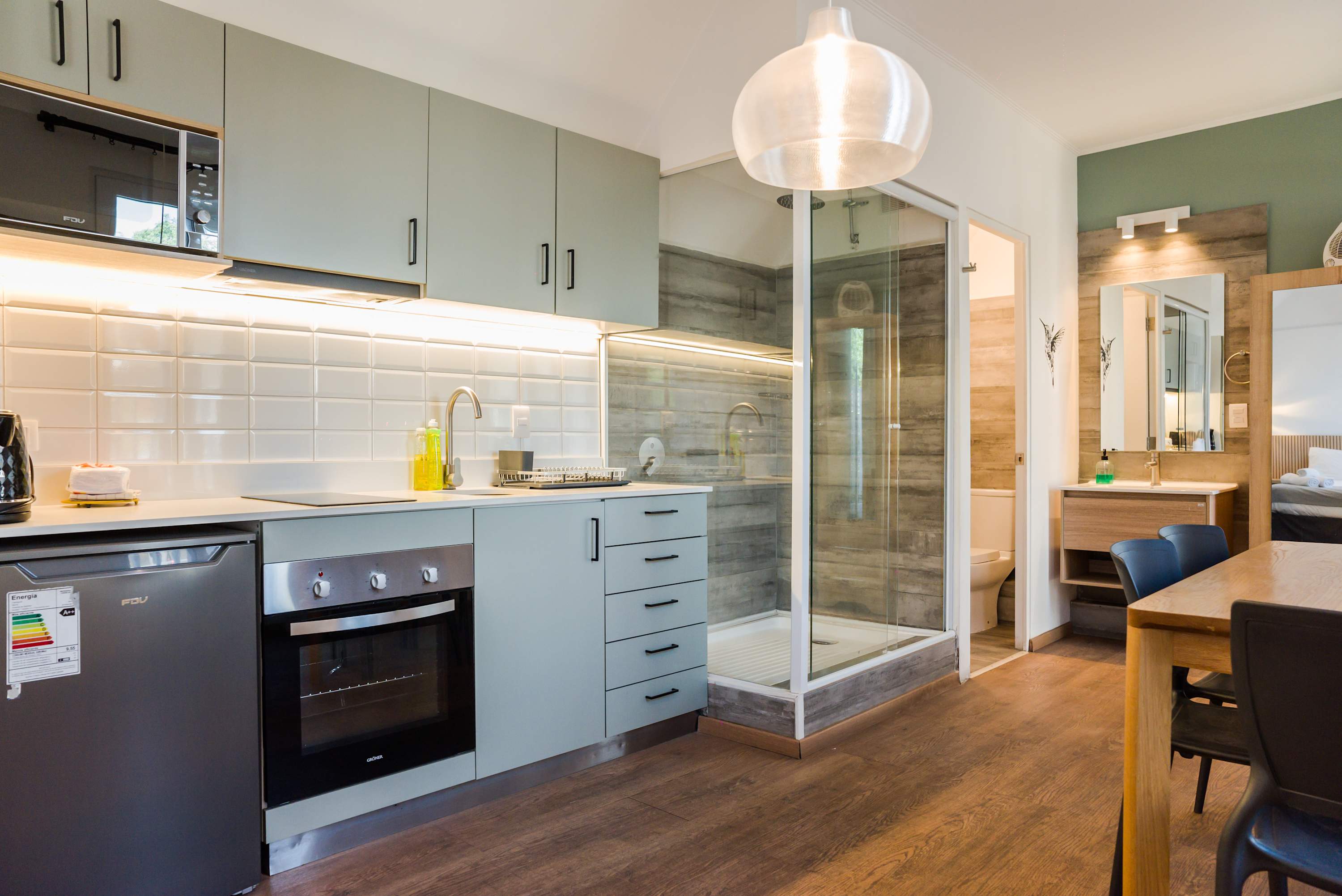 Chic studio kitchen with modern amenities and stylish dining area, perfect for a cozy stay.