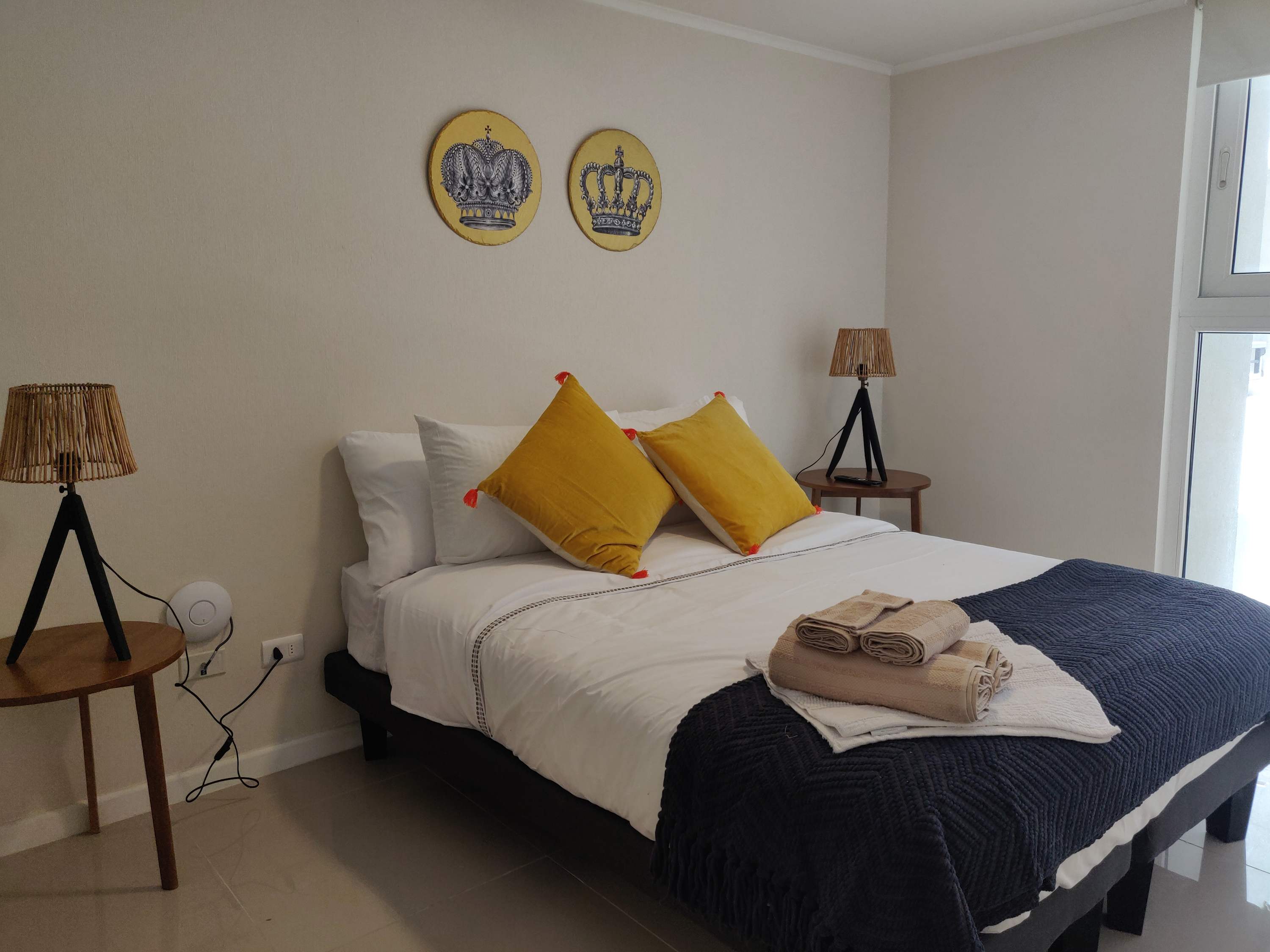 Relax in this cozy bedroom with stylish decor and natural light, perfect for a restful stay.